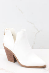 Outside view of white high heel booties featuring slits on the ankle.
