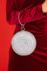 Full view of this bag that features silver hardware, rhinestone and jewel detailing, a circular handle, an optional chain strap, and a snap closure.