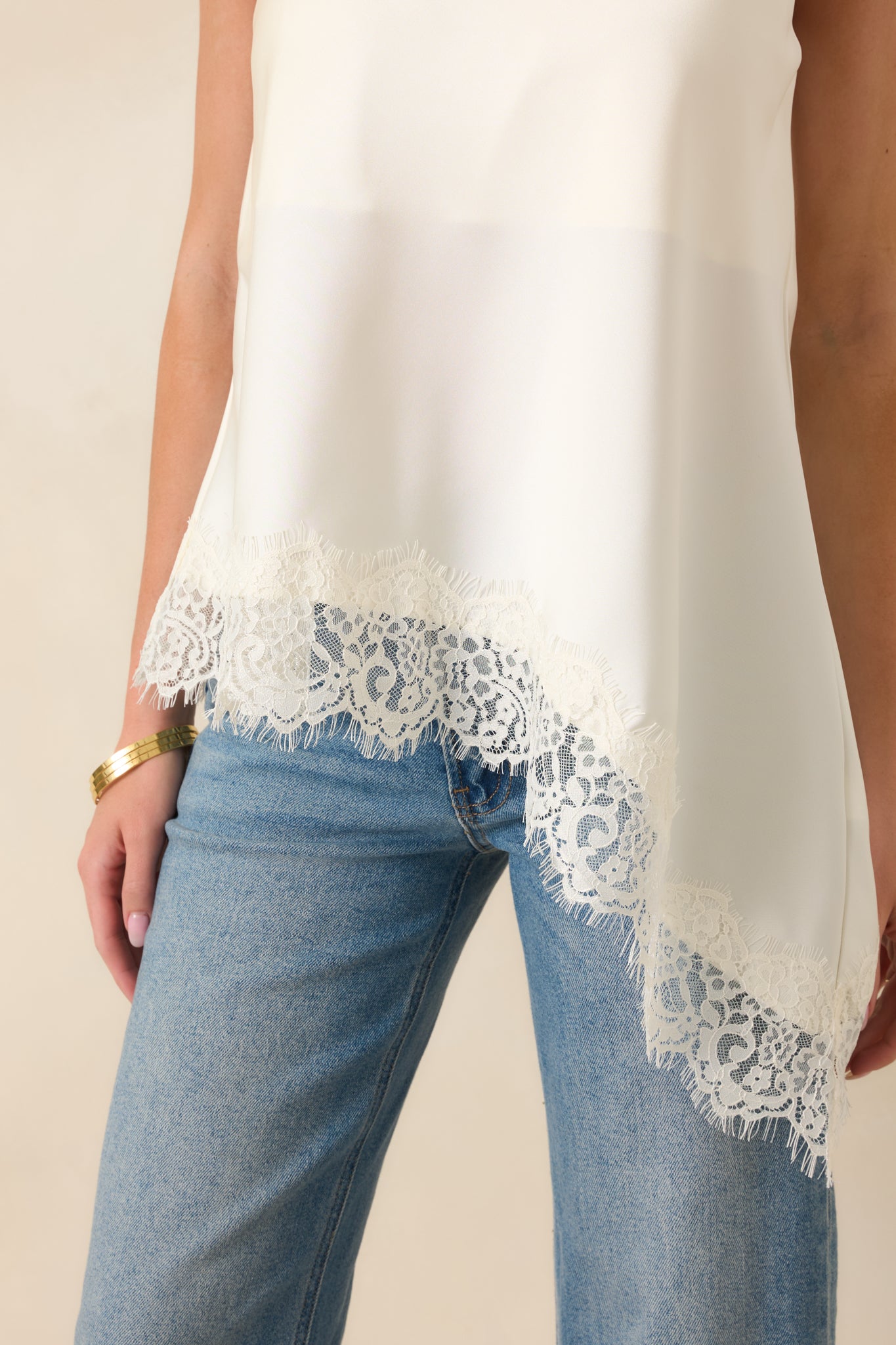 Ivory halter neckline highlighted by delicate eyelash lace trim and lightweight woven fabric with a graceful drape.