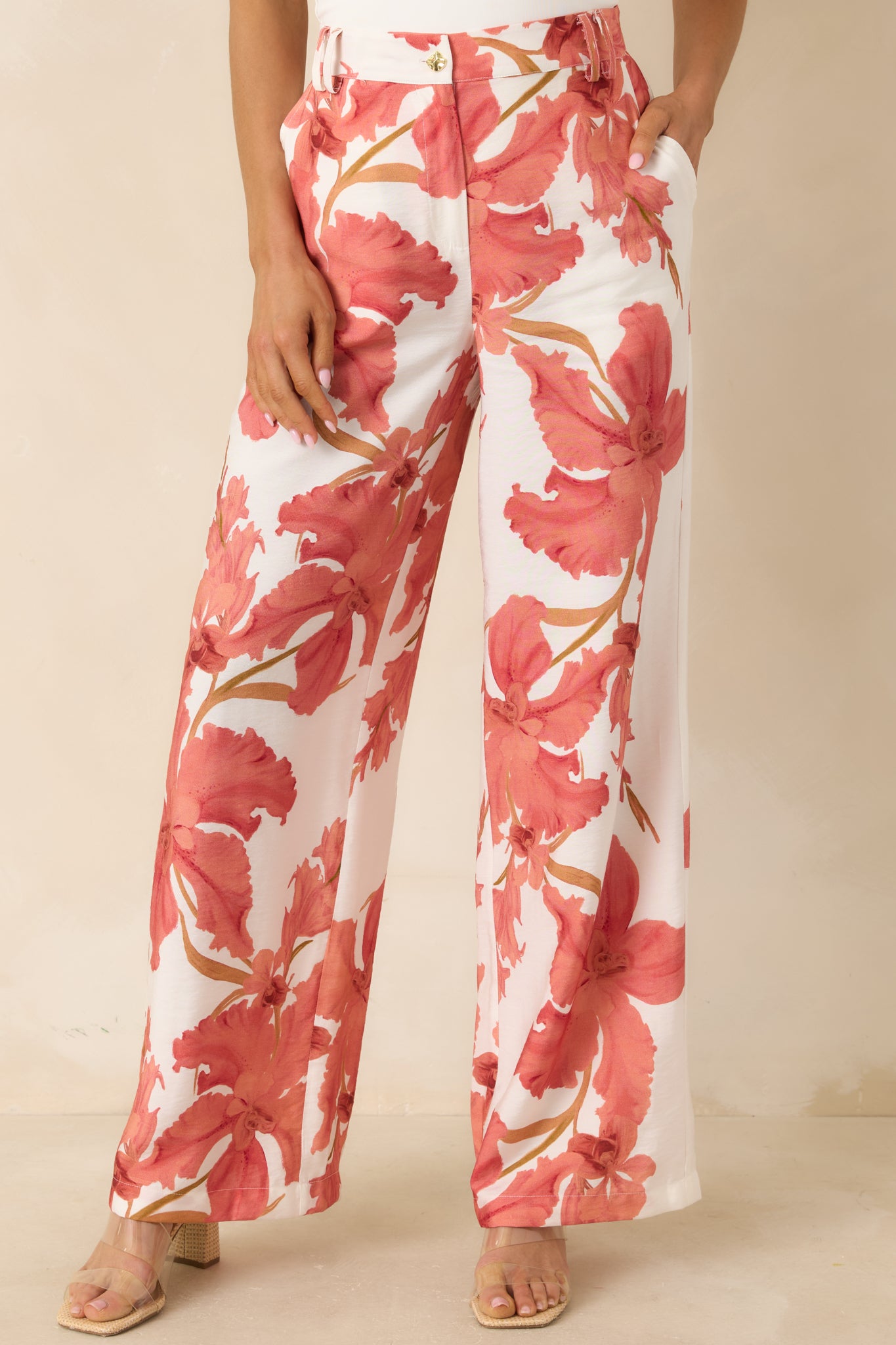 Close crop of floral wide leg pants showcasing the soft peach palette and flowing fabric.