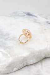 Front view of rose quarts ring with an adjustable gold band. 