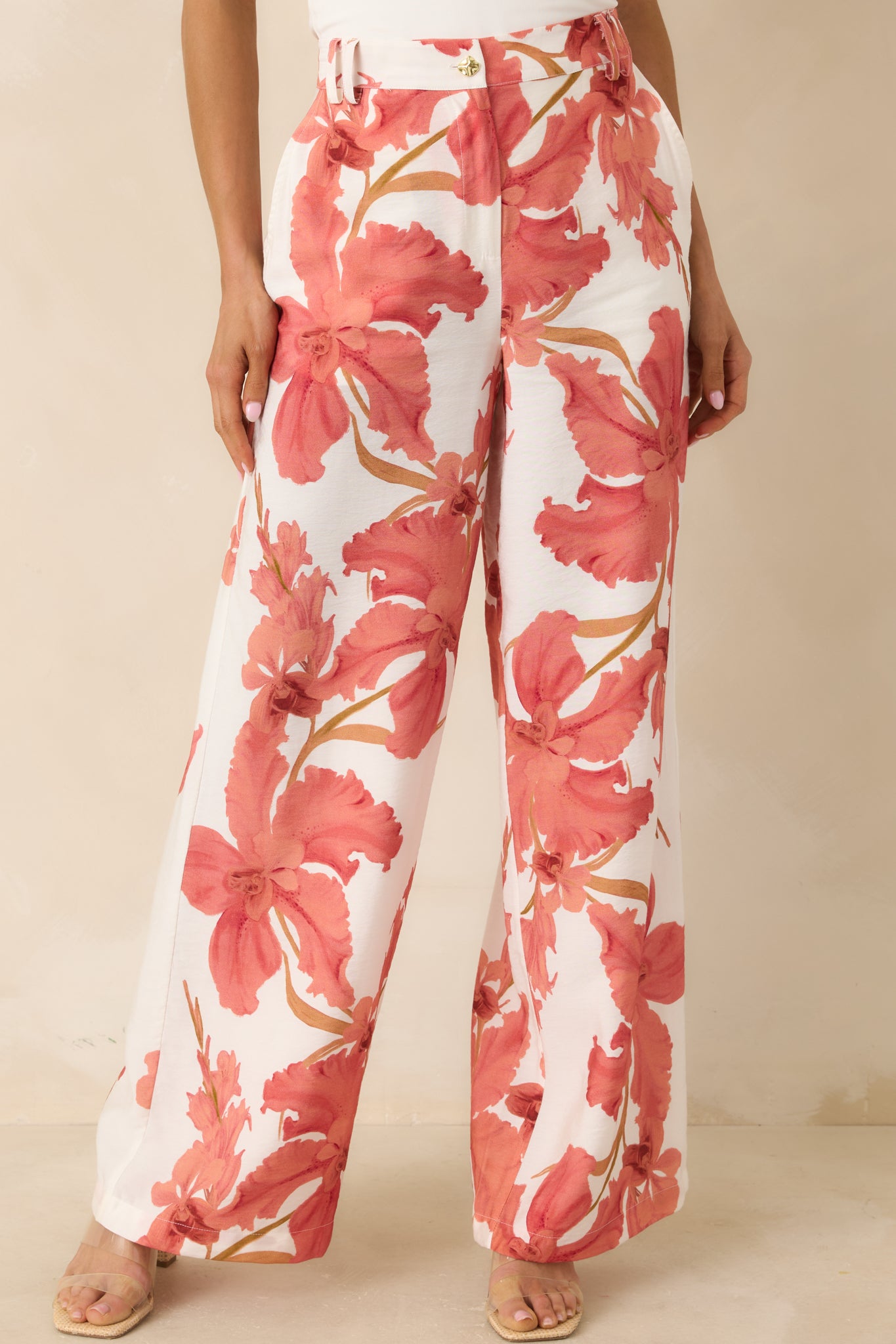 Front-facing crop emphasizing the relaxed fit and tailored details of the hibiscus print pants.