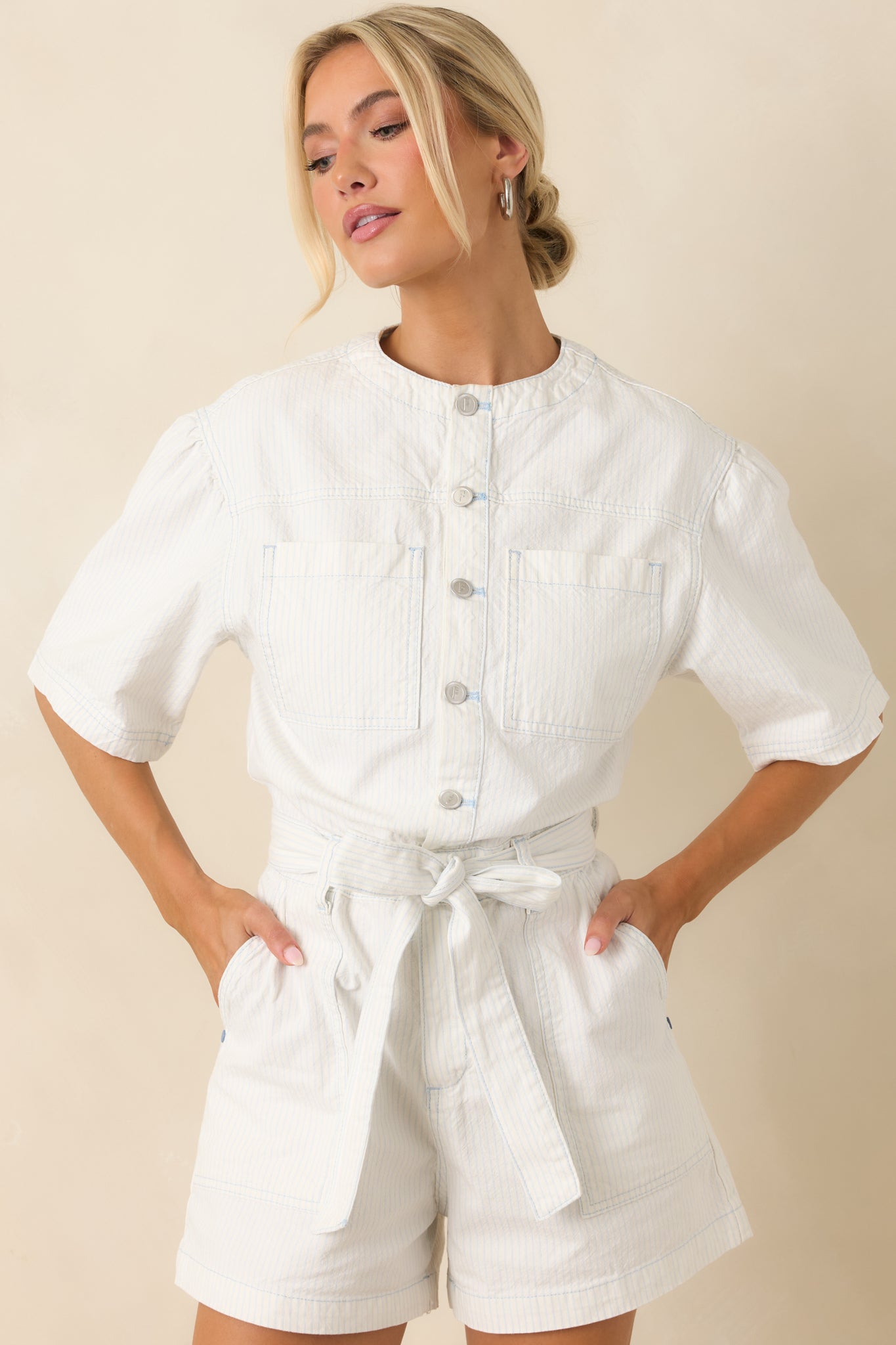Cropped detail focusing on chest patch pockets and fine textured cotton fabrication.