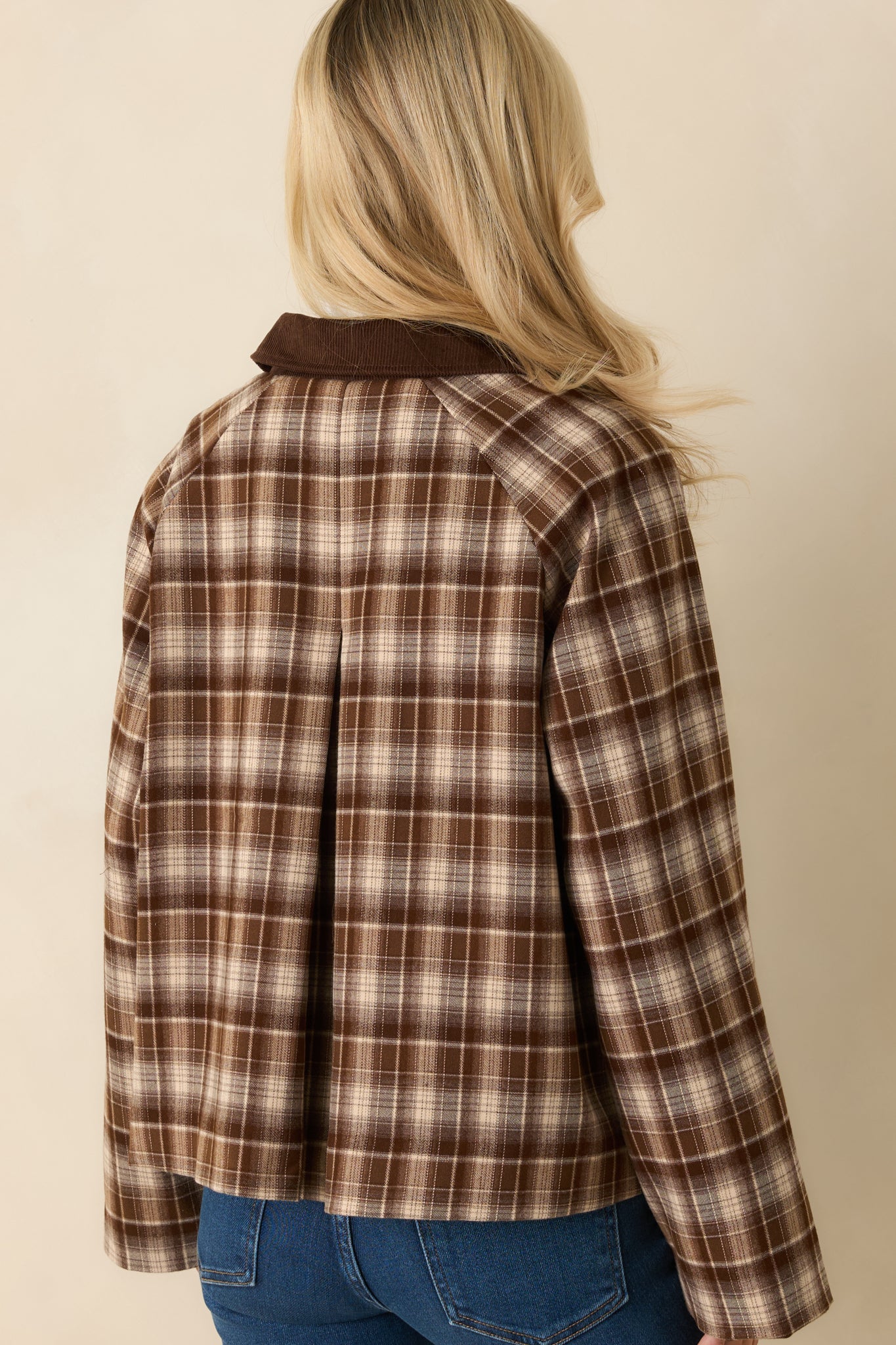 Rear view of the brown plaid jacket showing center-back pleat and straight hemline.