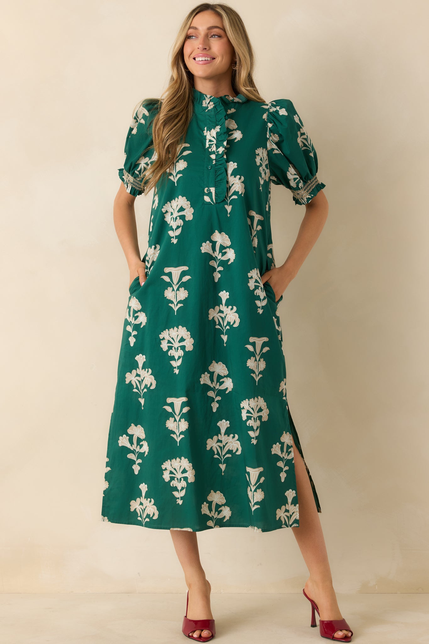 Front-facing full view of the green maxi dress with ivory floral print and ruffled mock neckline.