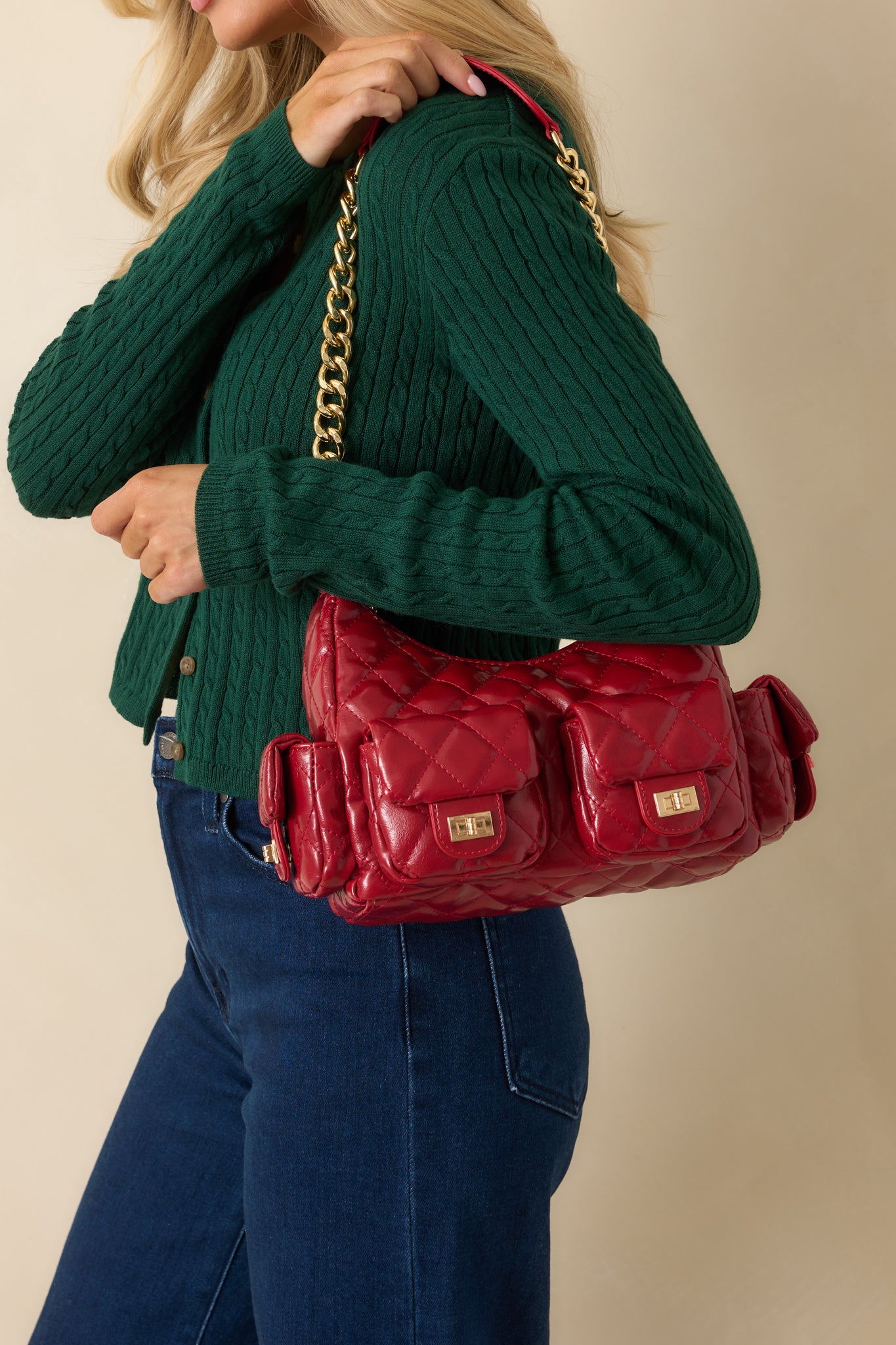 Quilted red handbag highlighting multiple exterior flap pockets with polished turn-lock closures