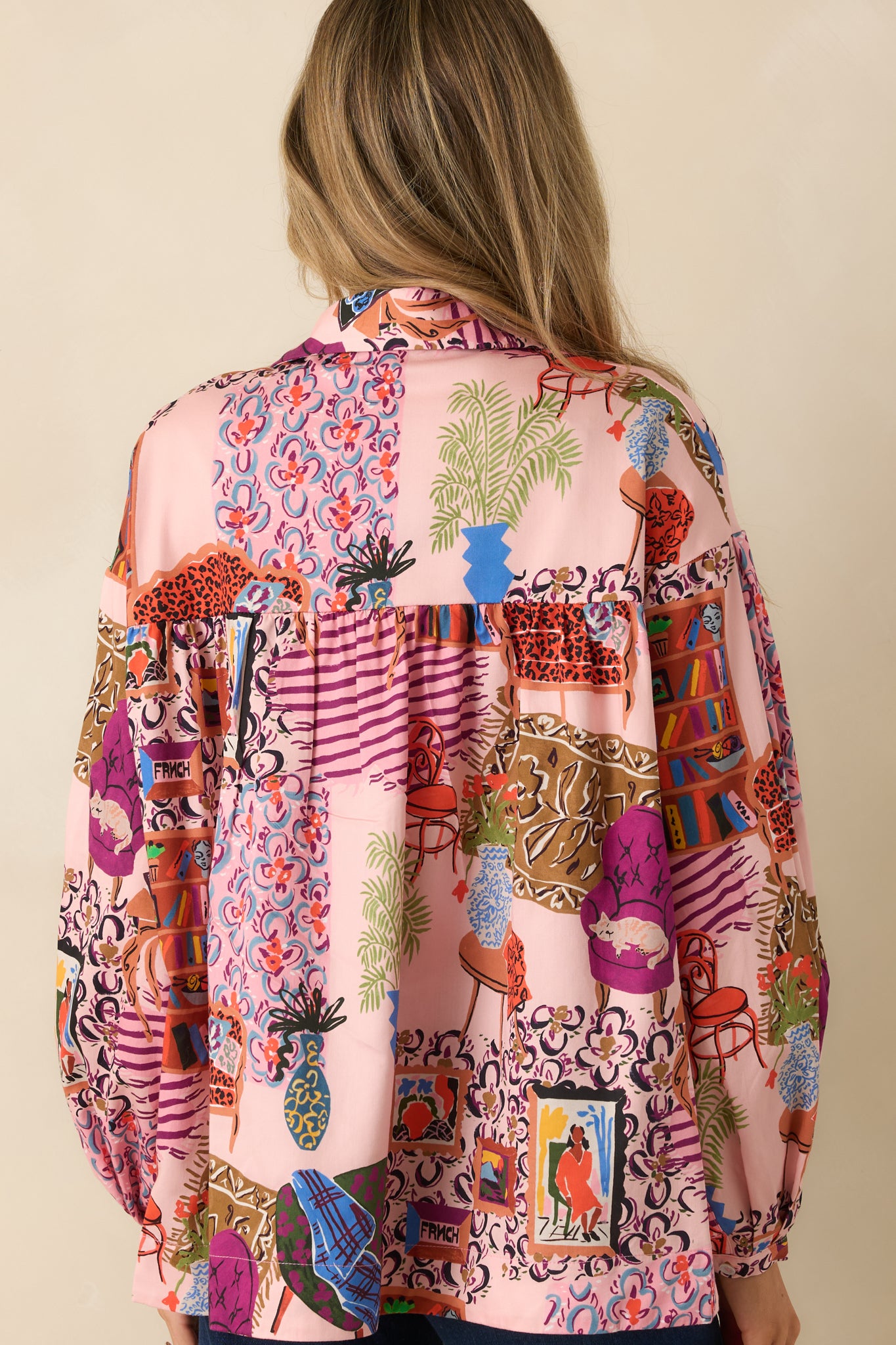 The back of the blouse displays the flowing silhouette and continuous multi-color print across the lightweight woven fabric