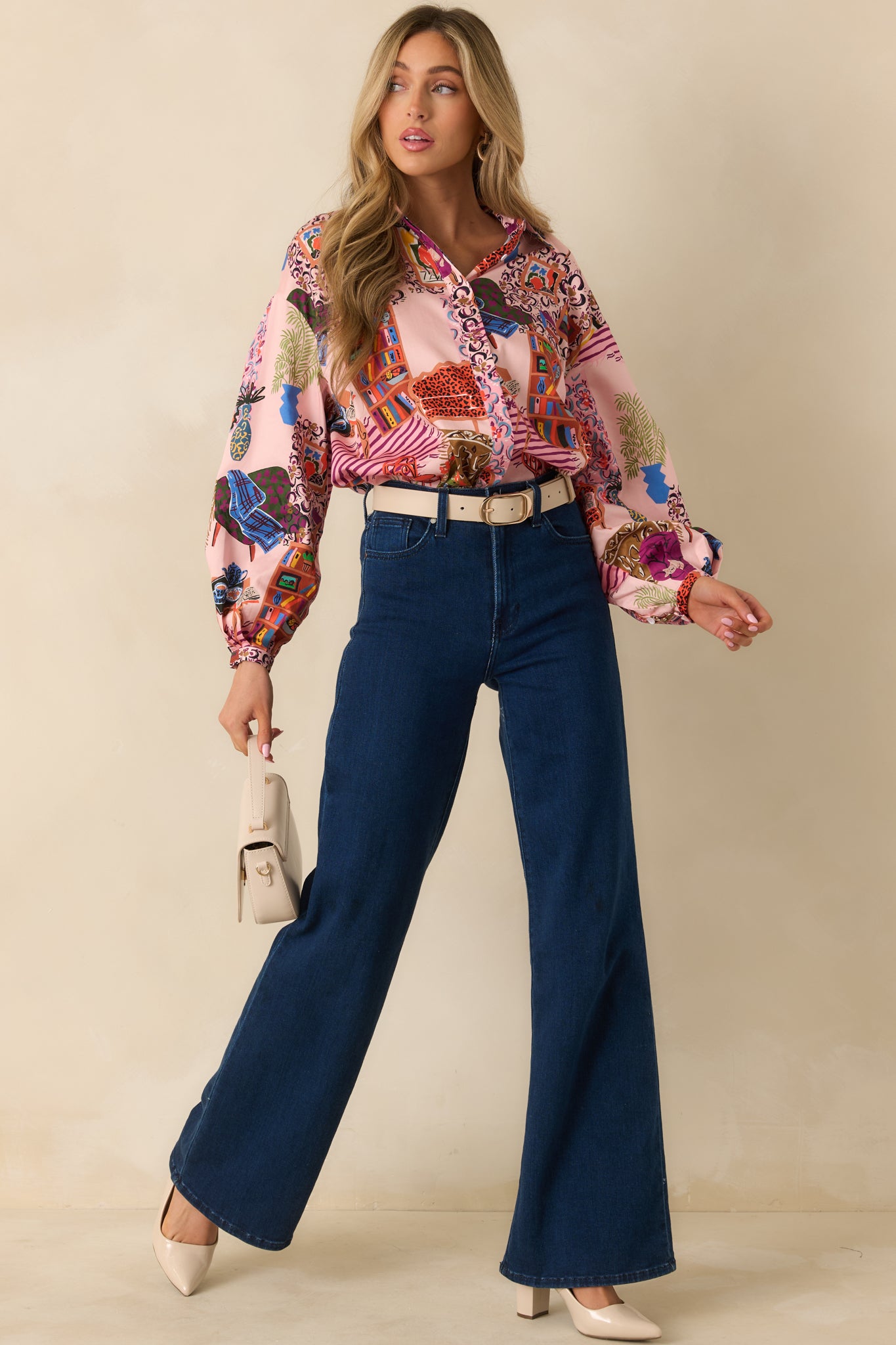The blouse displays its allover salon-inspired print with a pointed collar and relaxed button-up silhouette.