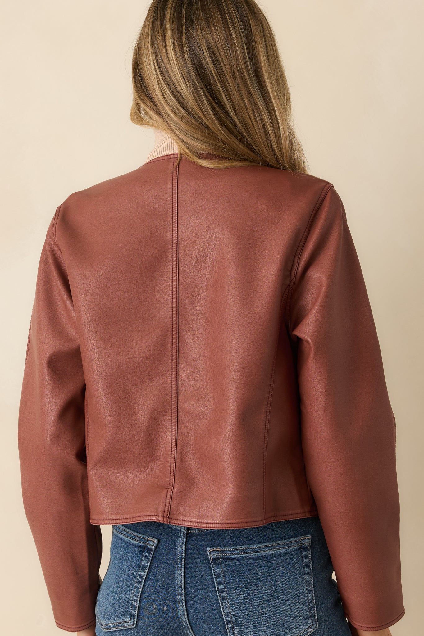 Rear view of the mauve faux leather jacket showing clean lines and structured shape.