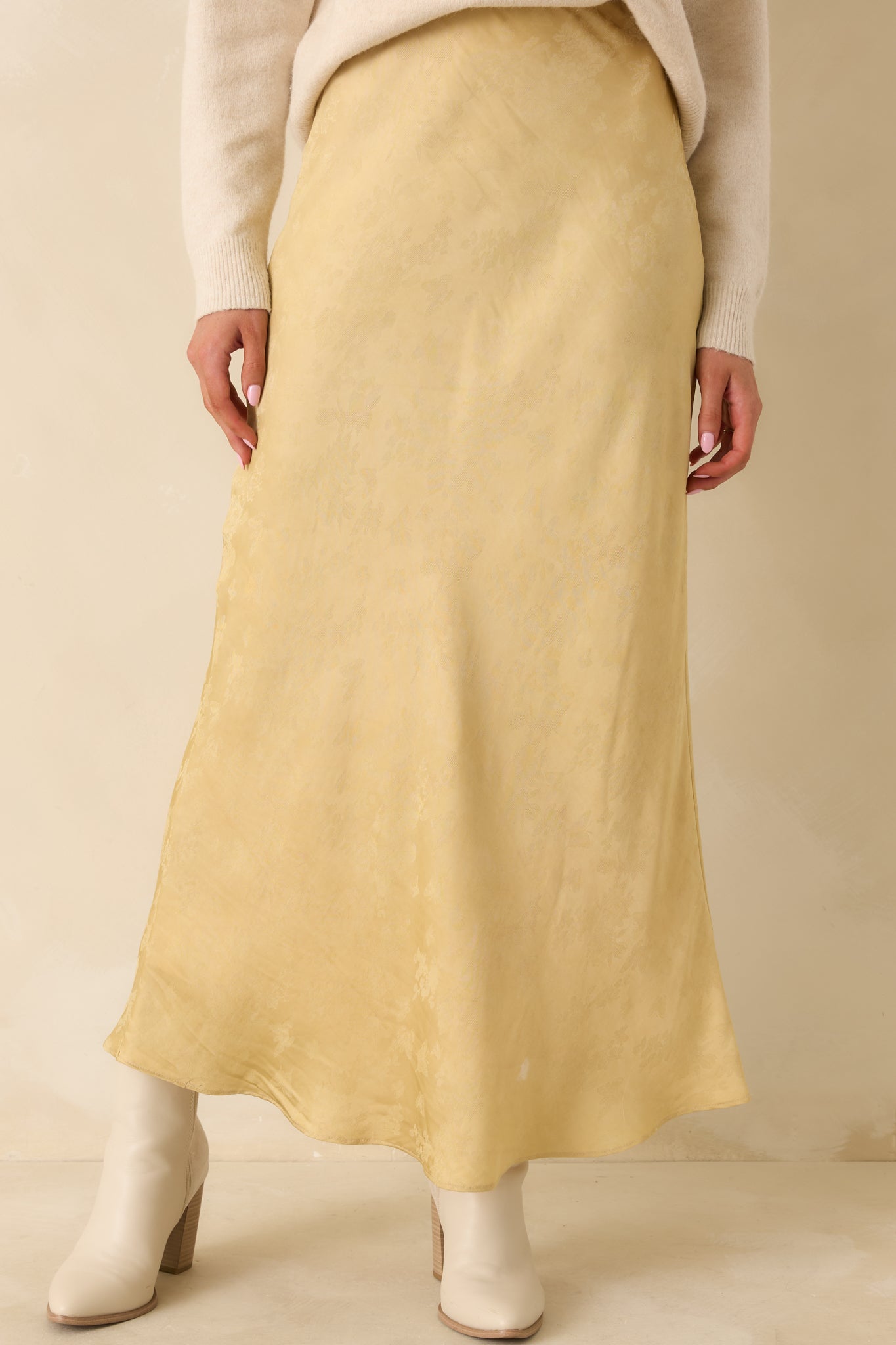 The skirt’s satin fabric and subtle floral detailing showcase the rich texture and elegant drape.