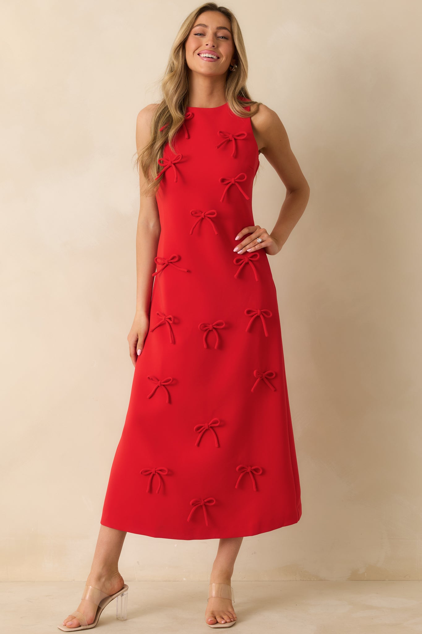 Front-facing red maxi dress with a sleeveless cut, straight silhouette, crew neckline, and scattered bow embellishments.