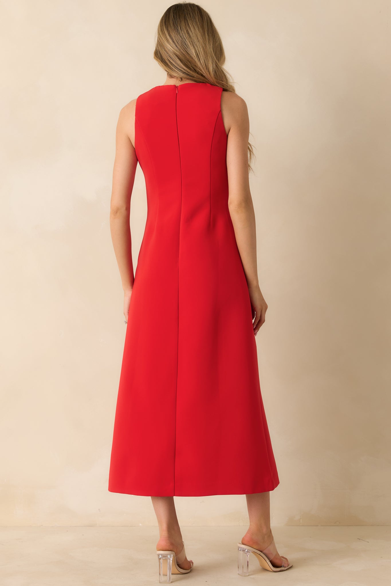Rear view of the red maxi dress with a hidden back zipper and bow appliqués along the straight silhouette.
