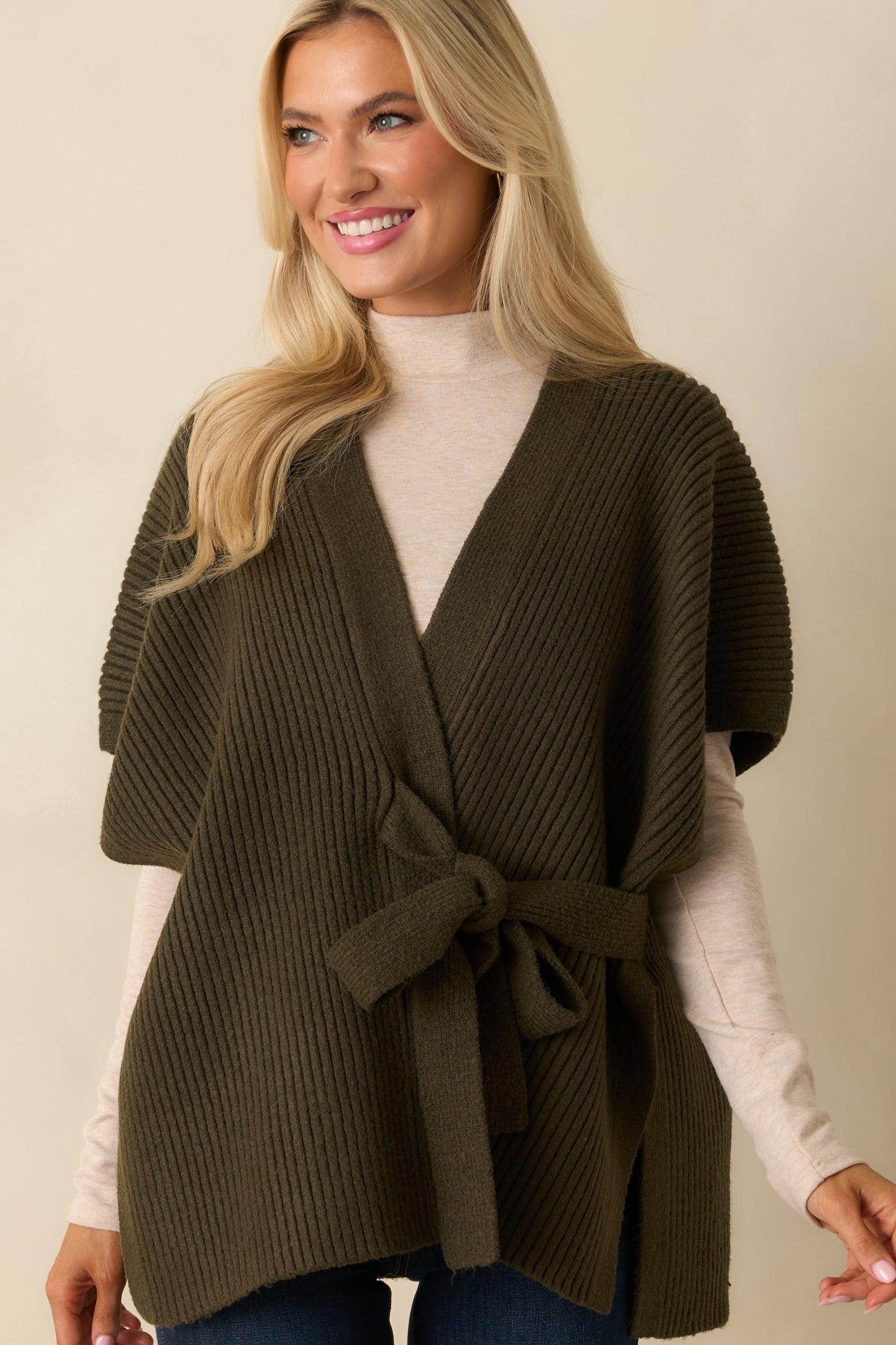 Cropped shot emphasizing short sleeves, ribbed fabric, and waist belt of the cardigan.