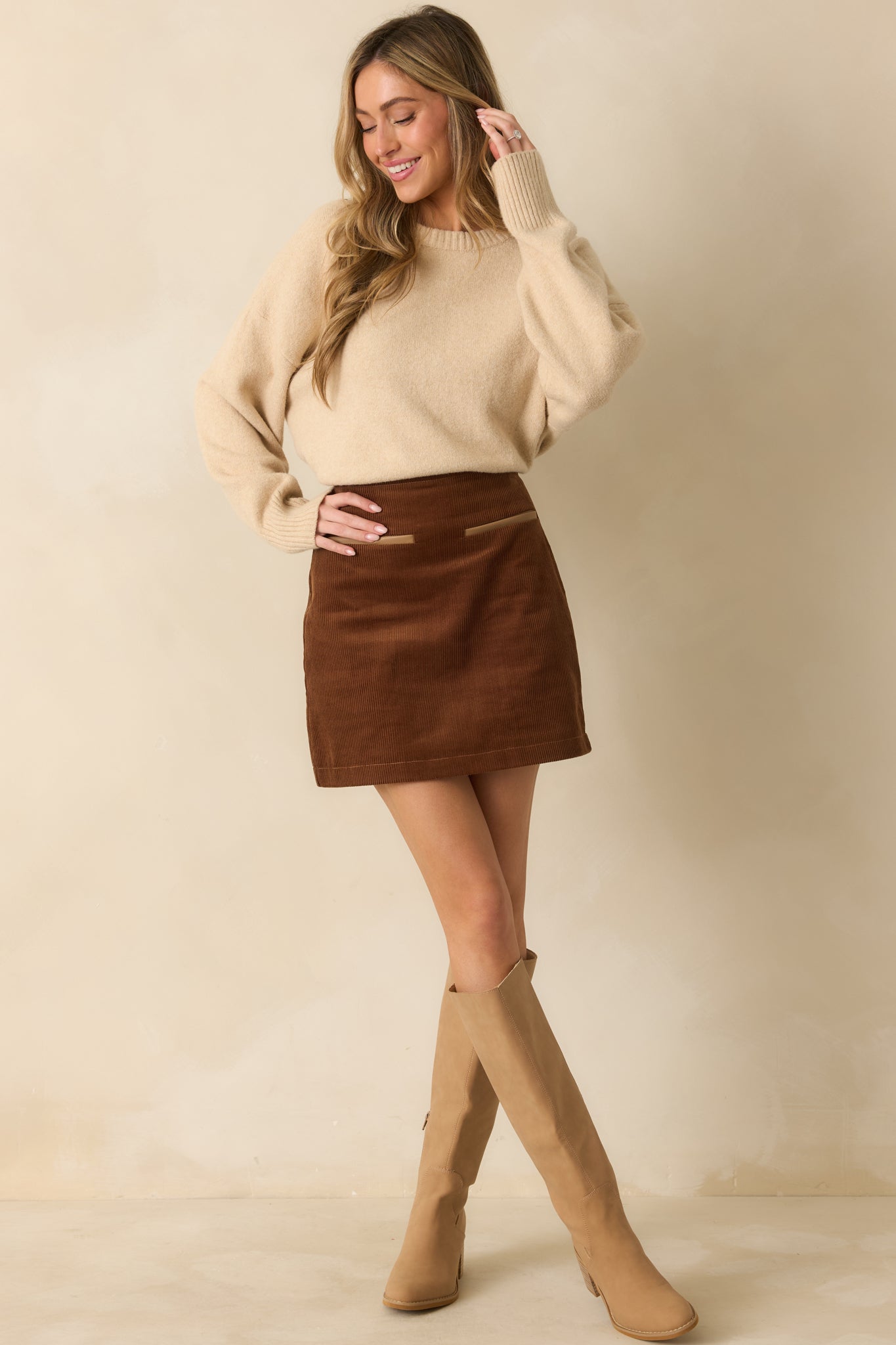 Afull body front view showing the brushed knit texture and relaxed fit of the beige sweater.