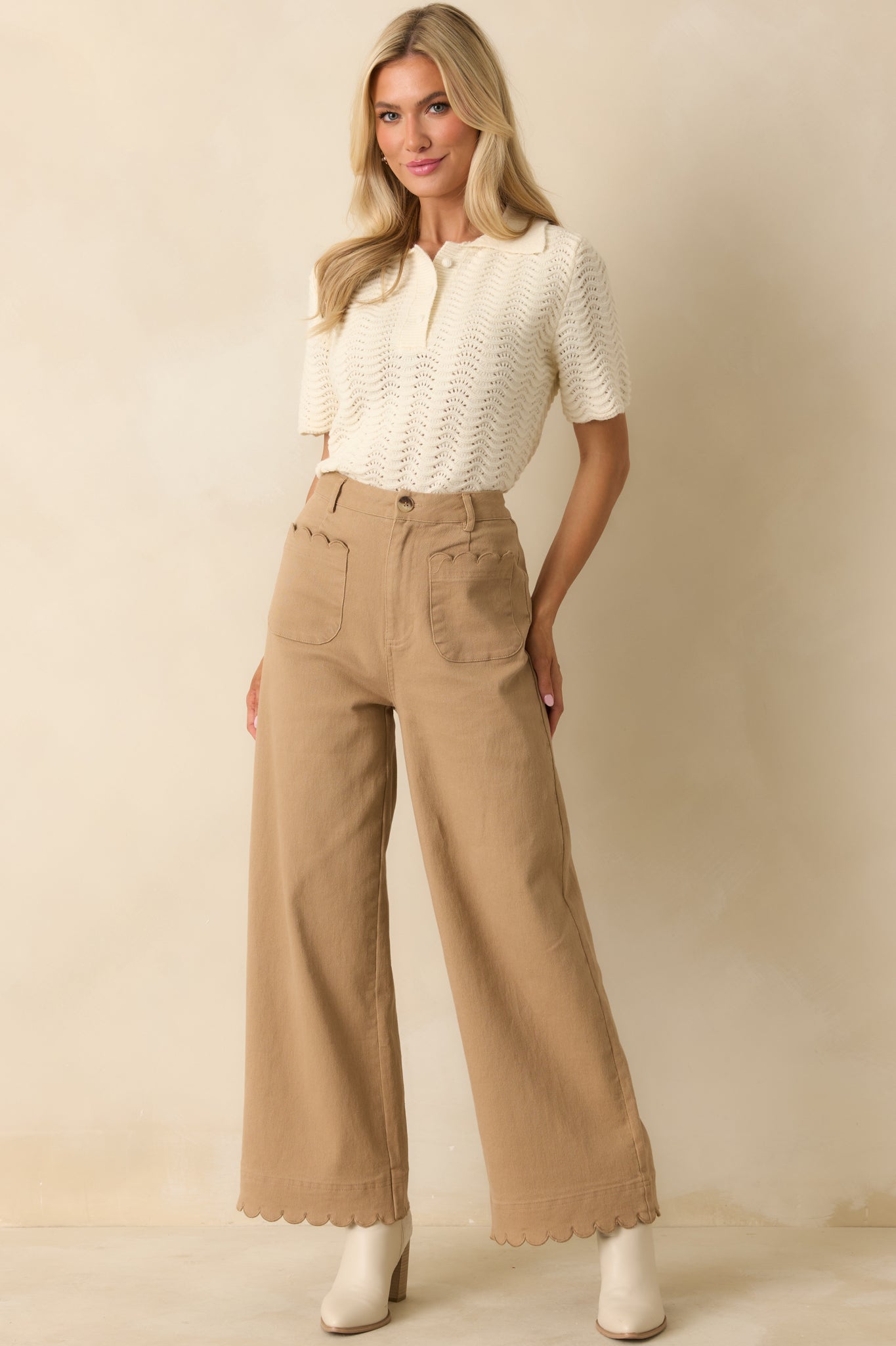 High-rise camel pants highlighting belt loops, front pockets, and chic silhouette.