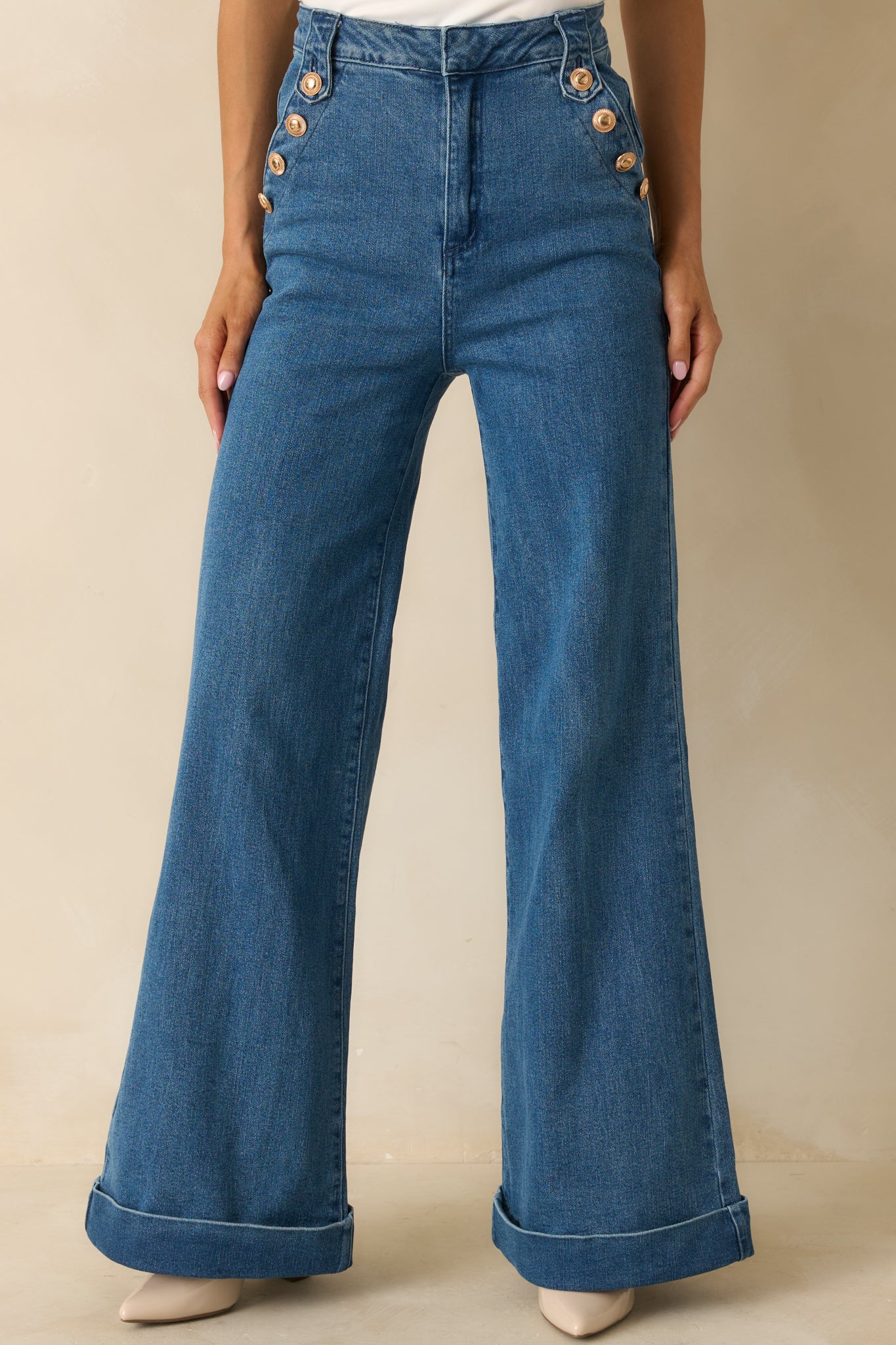 Cropped focus on gold-tone side buttons and smooth, soft fabric texture.