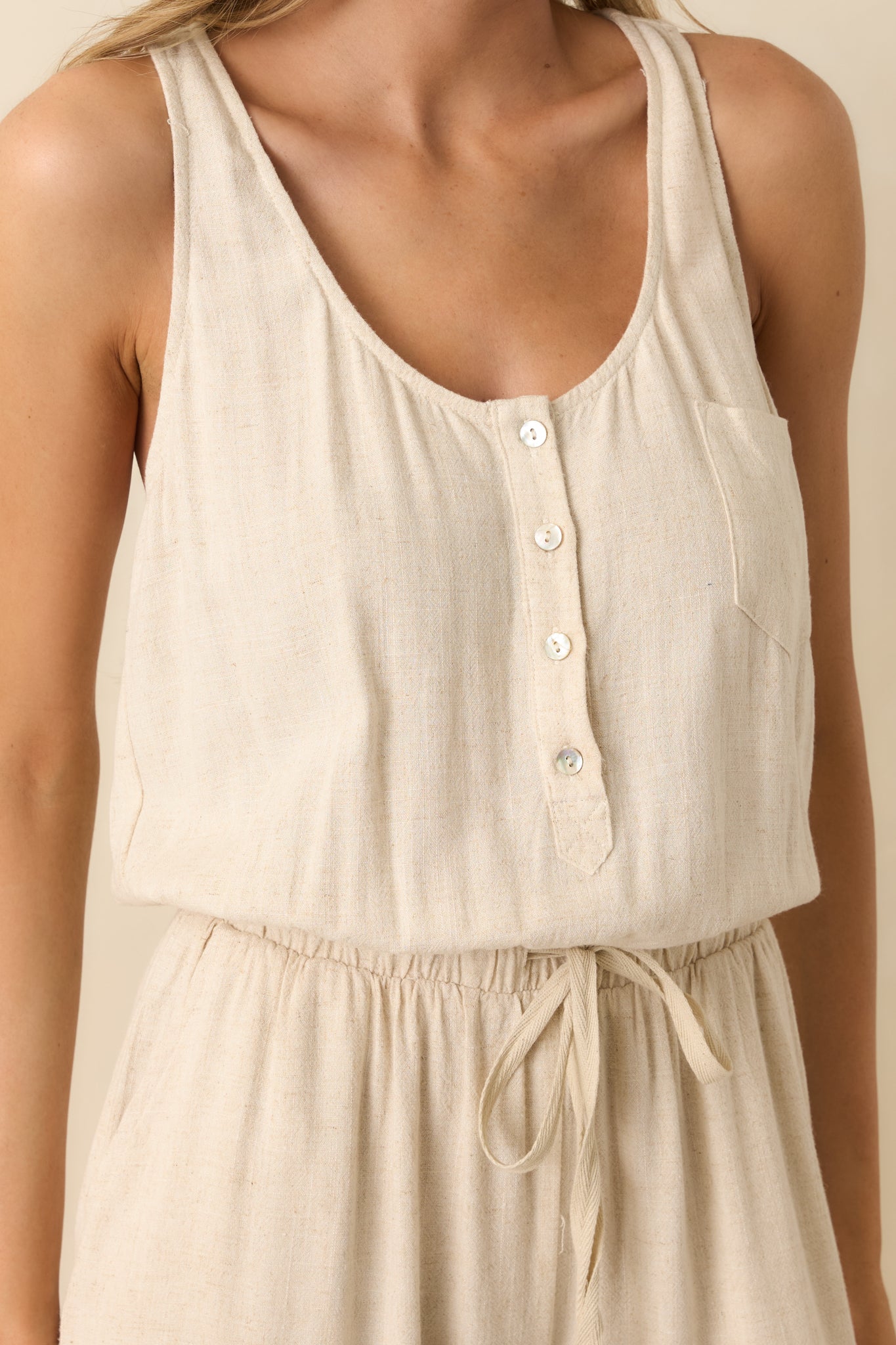 Close-up of jumpsuit’s buttons, scoop neckline, and fabric texture.