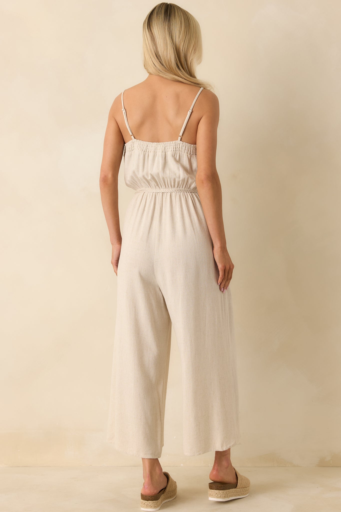 Rear view highlighting smocked back panel, adjustable straps, and relaxed wide-leg fit.