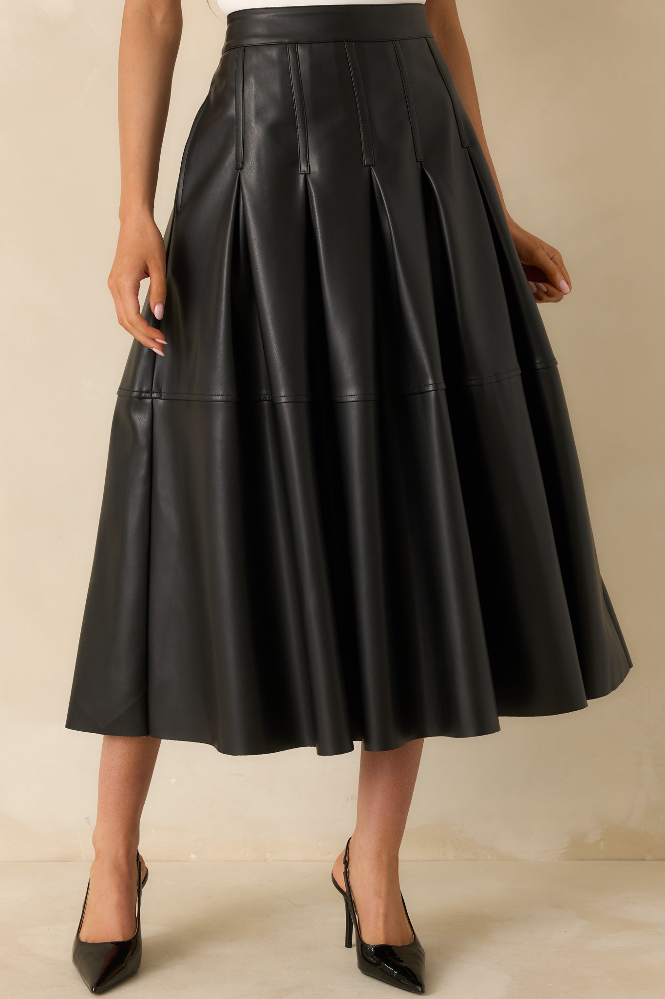 Cropped view highlighting the tailored vertical pleats and smooth A-line silhouette.