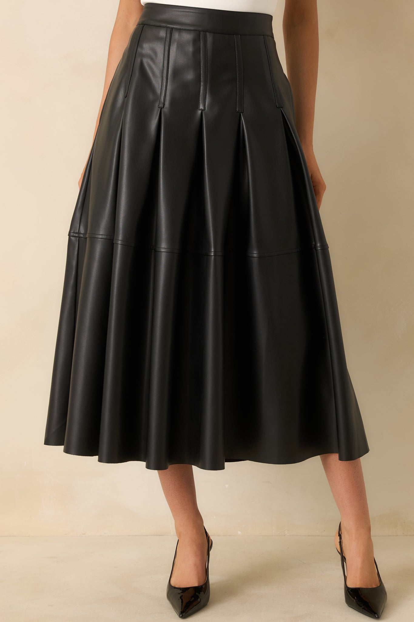 Cropped focus on the waist area and the clean, structured pleat detailing.