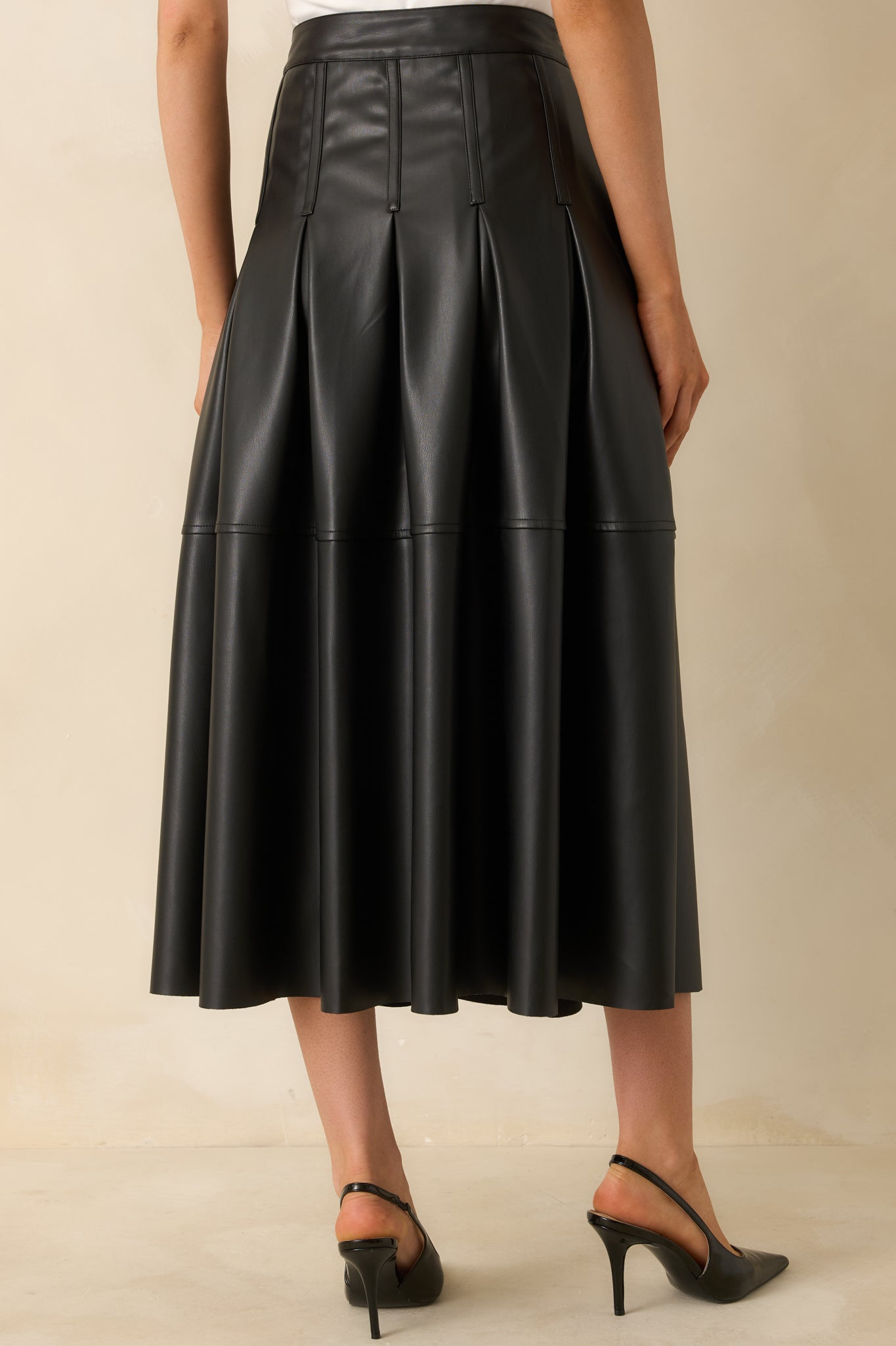 Rear view of the black midi skirt displaying the A-line flow and side zipper for easy wear.