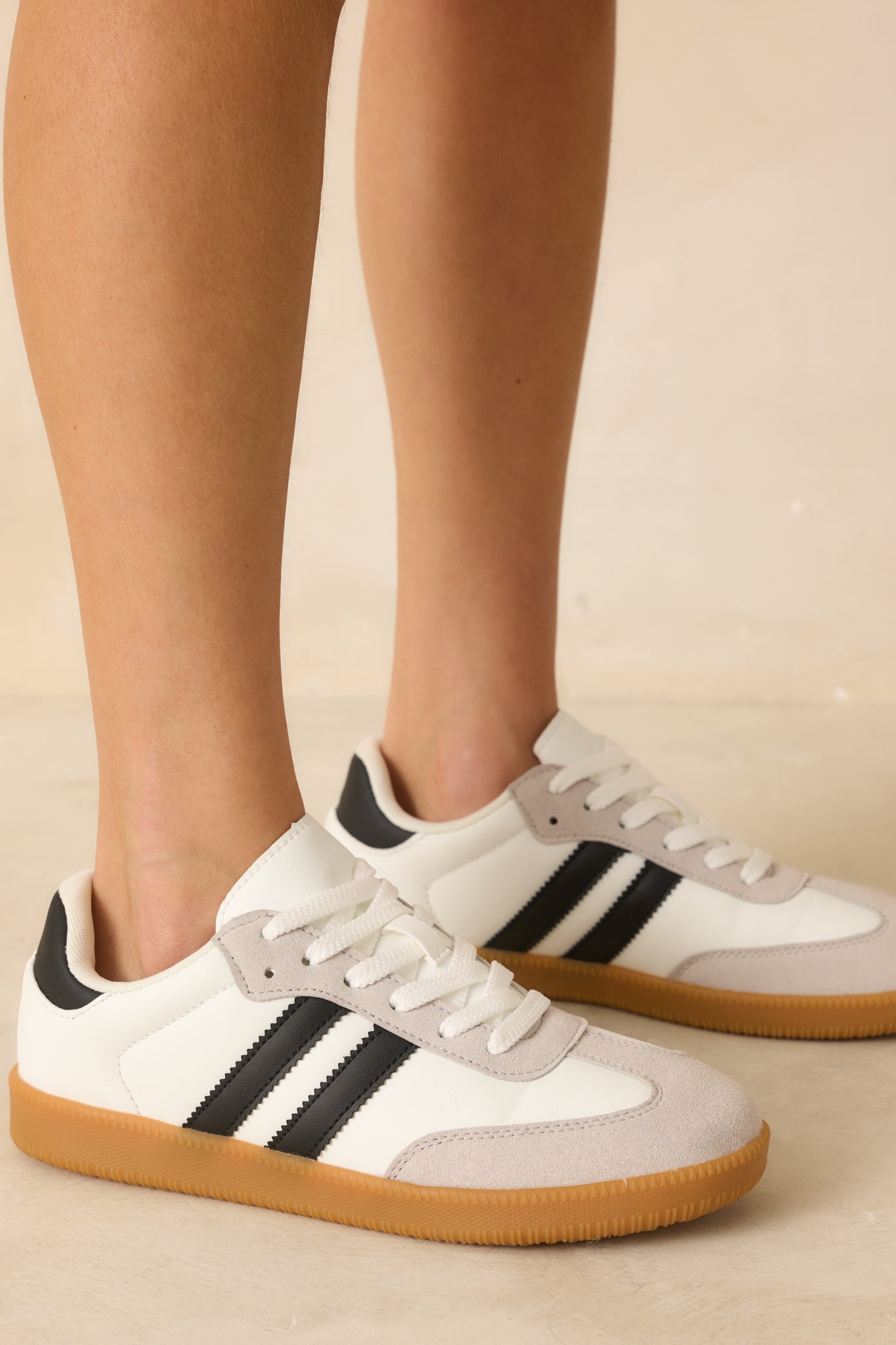 Zoomed-in shot of sneaker materials showing the contrast between smooth faux leather, soft faux suede, and gum rubber sole texture.