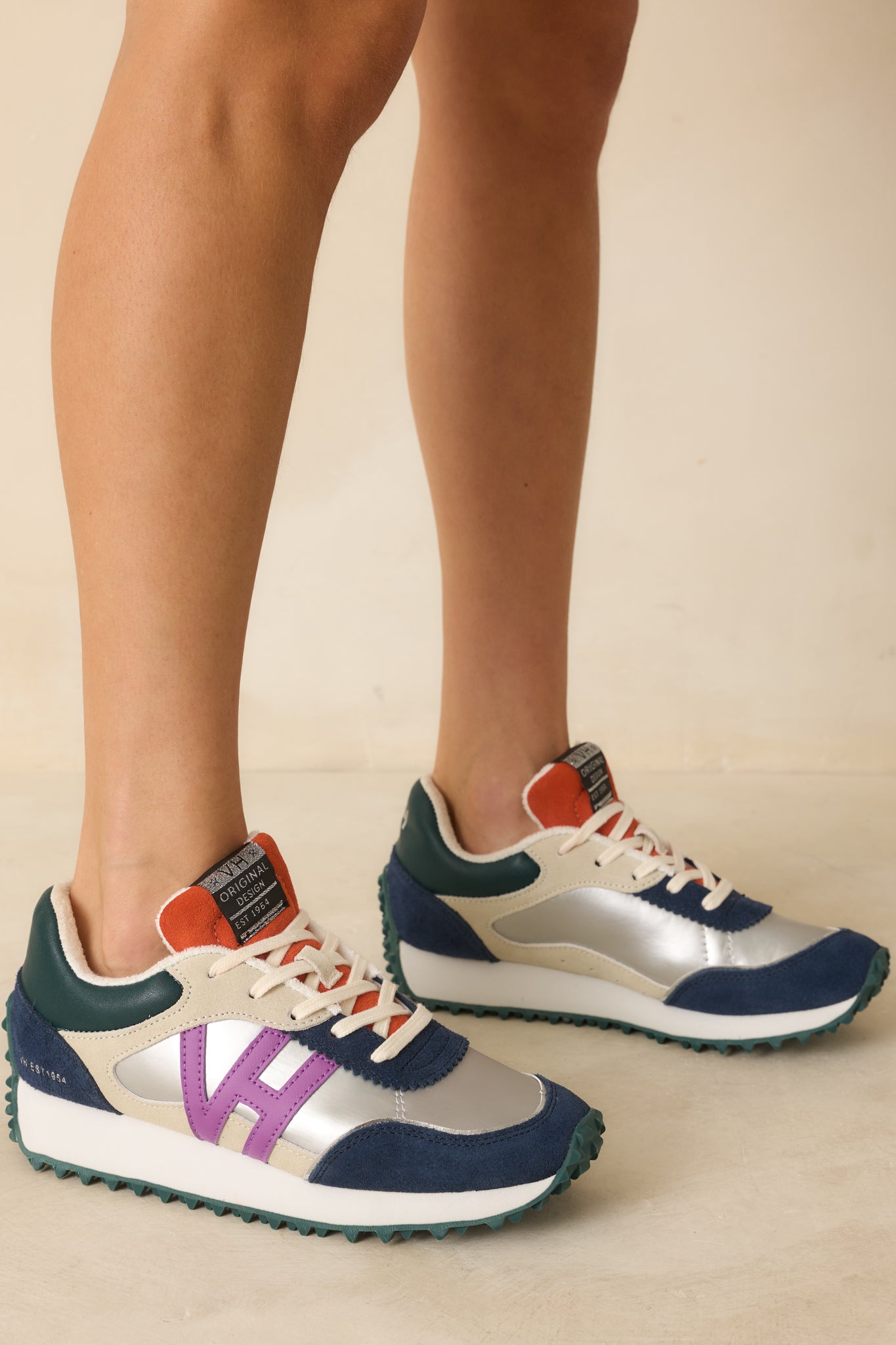 Side view of the silver sneakers showing the rounded toe, subtle pops of purple, navy, and orange, and the textured sole.