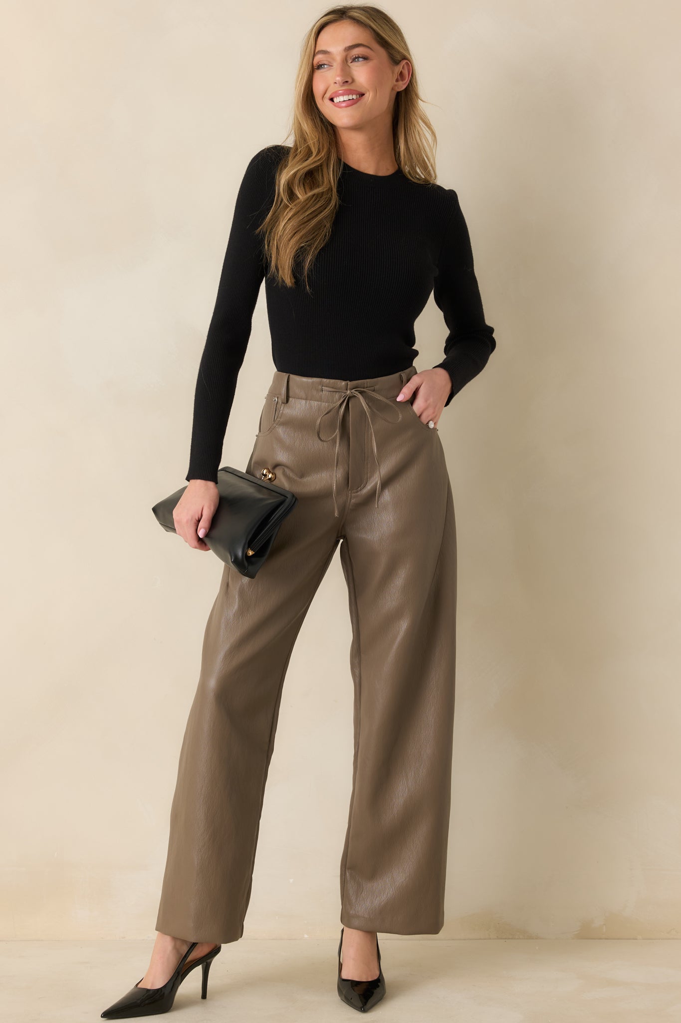 High-waisted faux leather pants designed with a straight leg cut and soft structured drape.