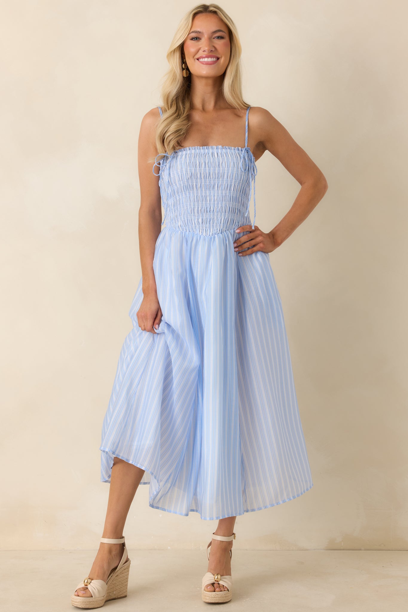 Light blue striped dress with dainty self-tie shoulder straps and a lightweight, flowing skirt.
