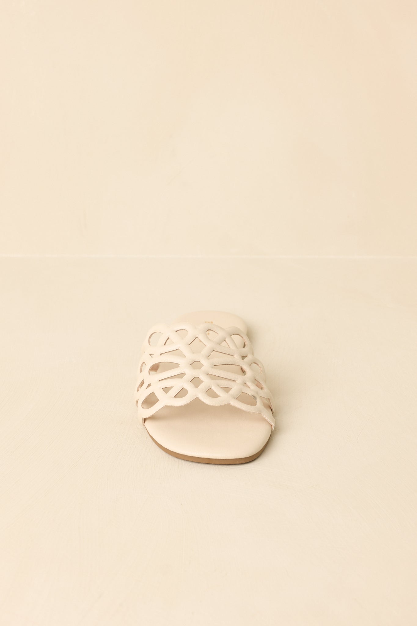 Front view of ivory slide sandals displaying open toe and wide strap design.