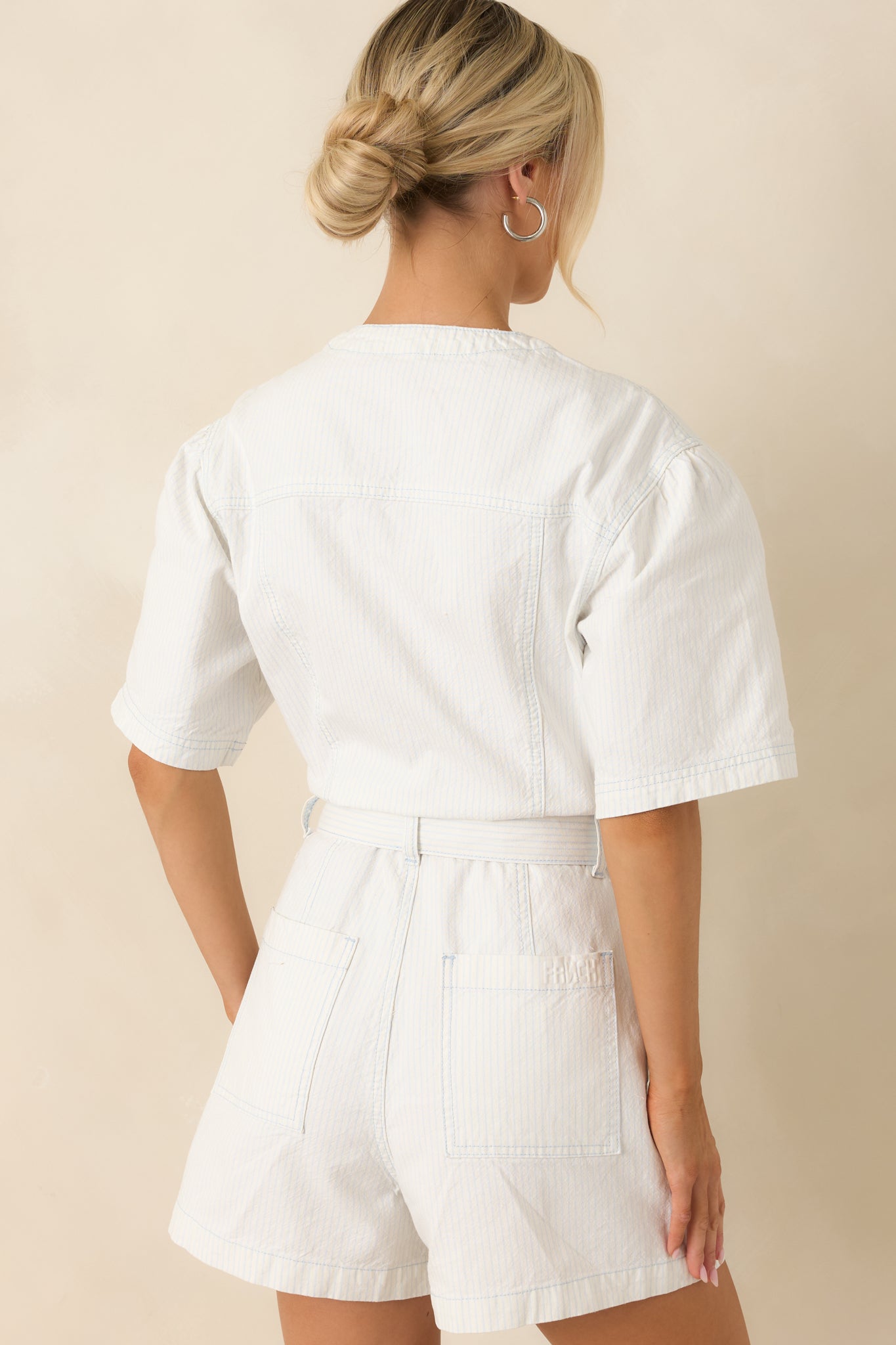 Rear view of striped cotton playsuit highlighting back pockets, relaxed fit, and tailored short structure.