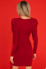 Back view of this dress that features a v-neckline with snap button closure, puff shoulders, ruffle detailing along the hips, and a back zipper closure.