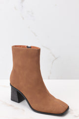 Outside view of brown high heel booties featuring a slightly square toe, and a chunky heel.