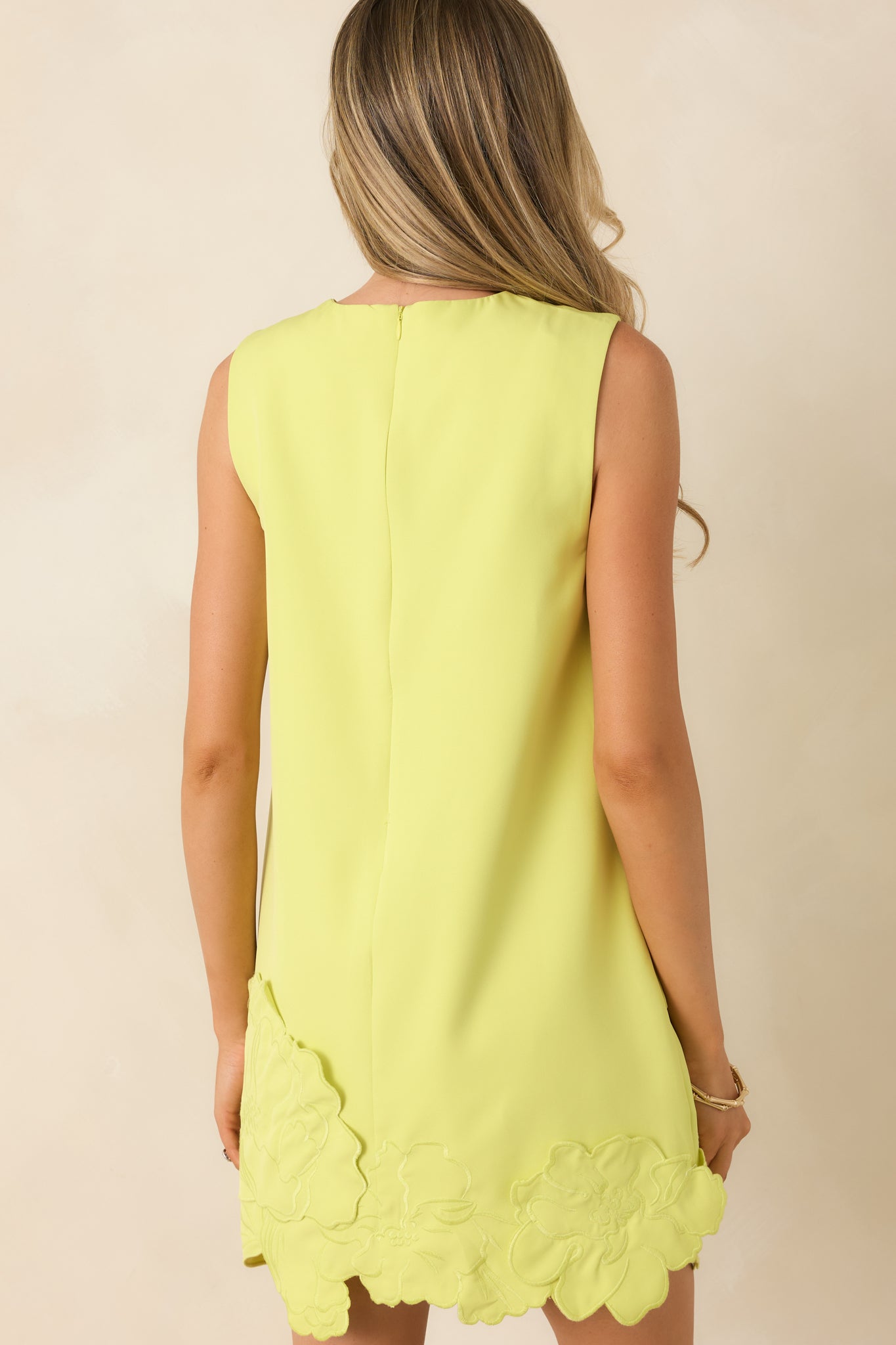 Rear view of chartreuse shift dress featuring sleeveless cut and relaxed straight silhouette.

