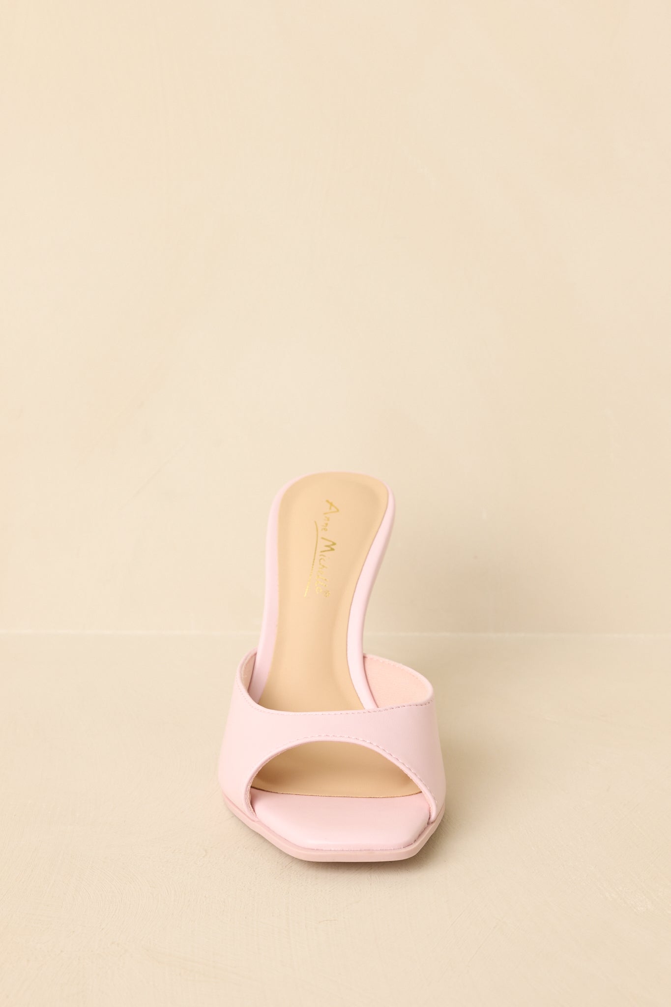 Front view of pink mule heels displaying square toe and single band upper.