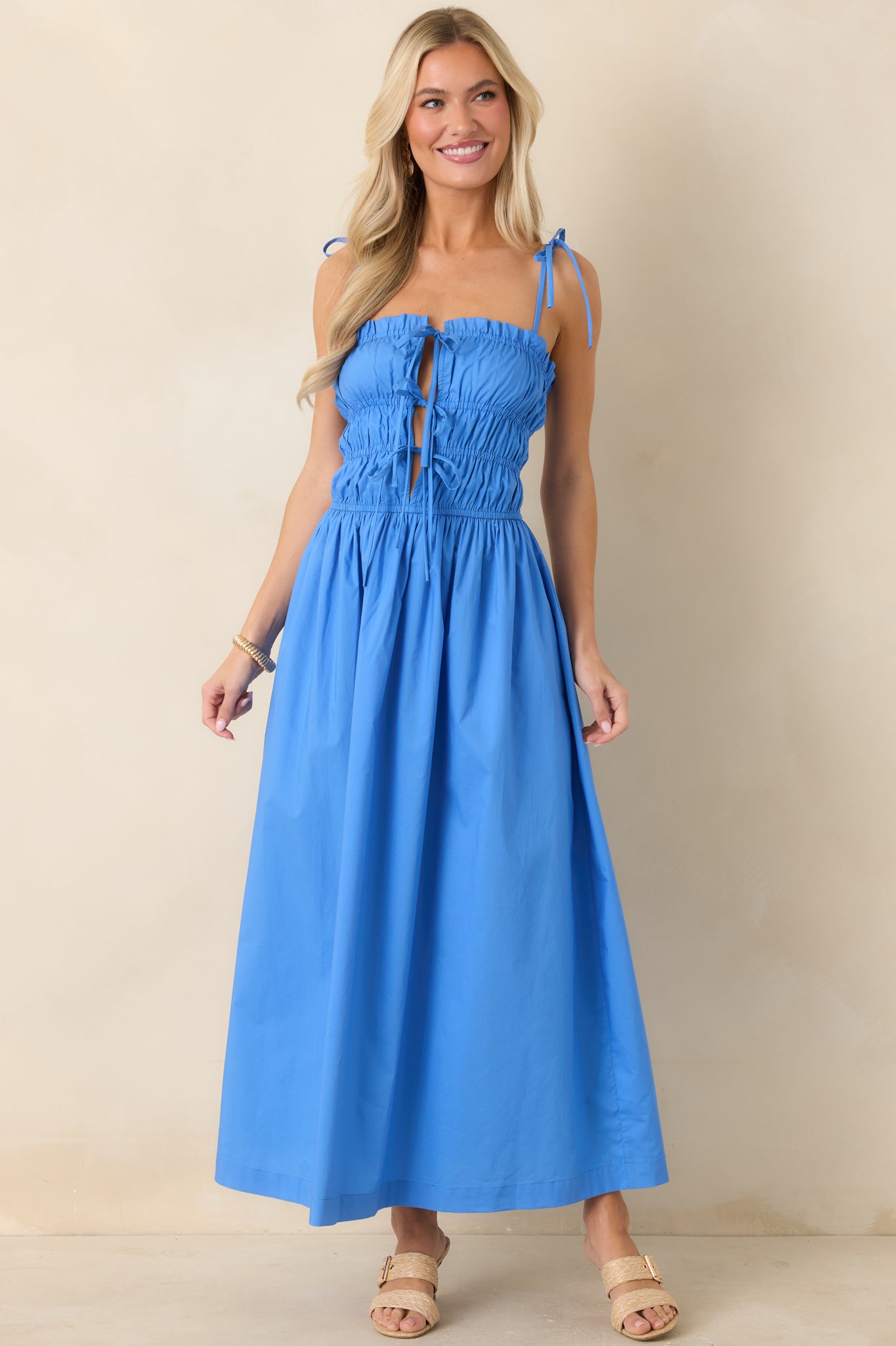Romantic midi dress featuring shoulder tie straps and a flowing full skirt silhouette.