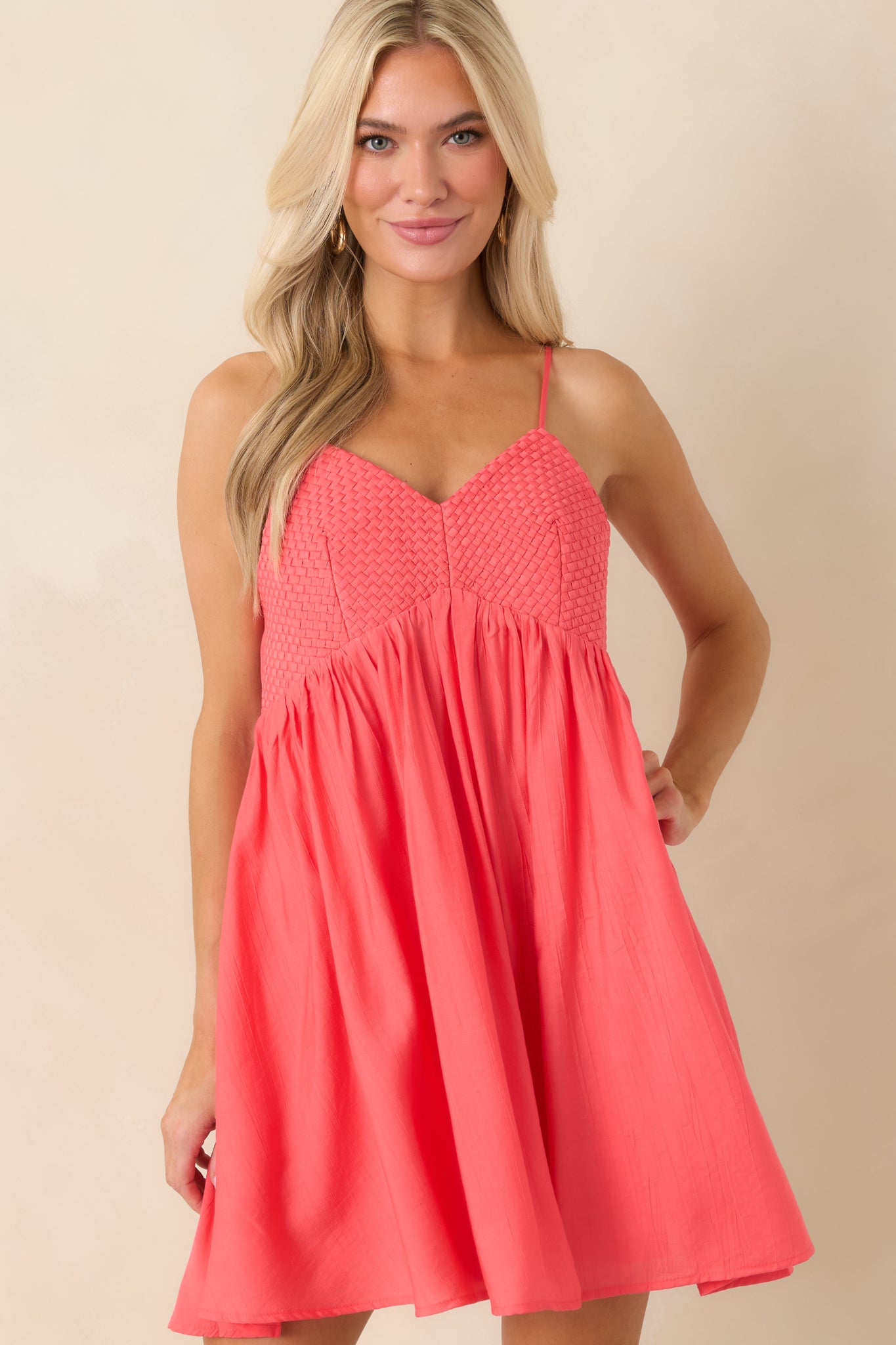 Coral pink mini dress highlighting textured bust and gathered seam.
