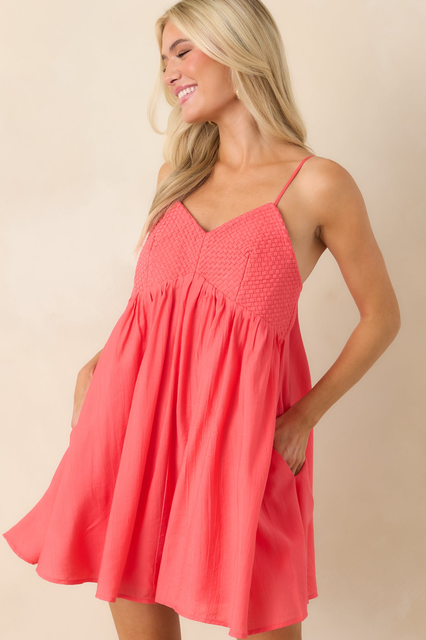 Coral pink dress showcasing gathered silhouette and lightweight fabric.