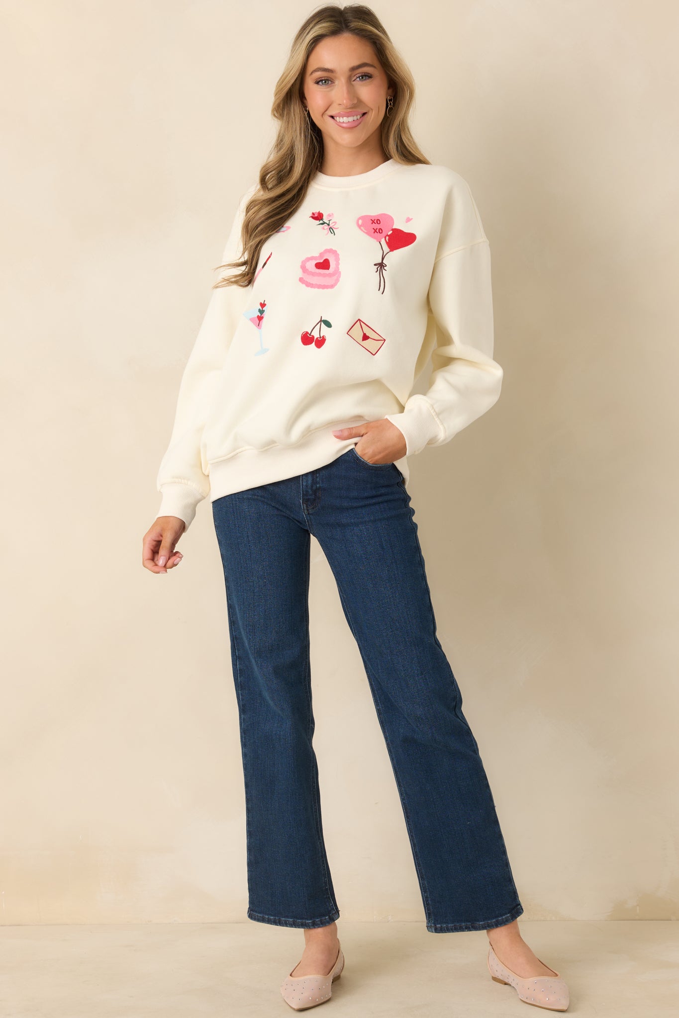Full front view of the ivory crewneck sweatshirt featuring a relaxed fit and colorful Valentine-inspired graphics.