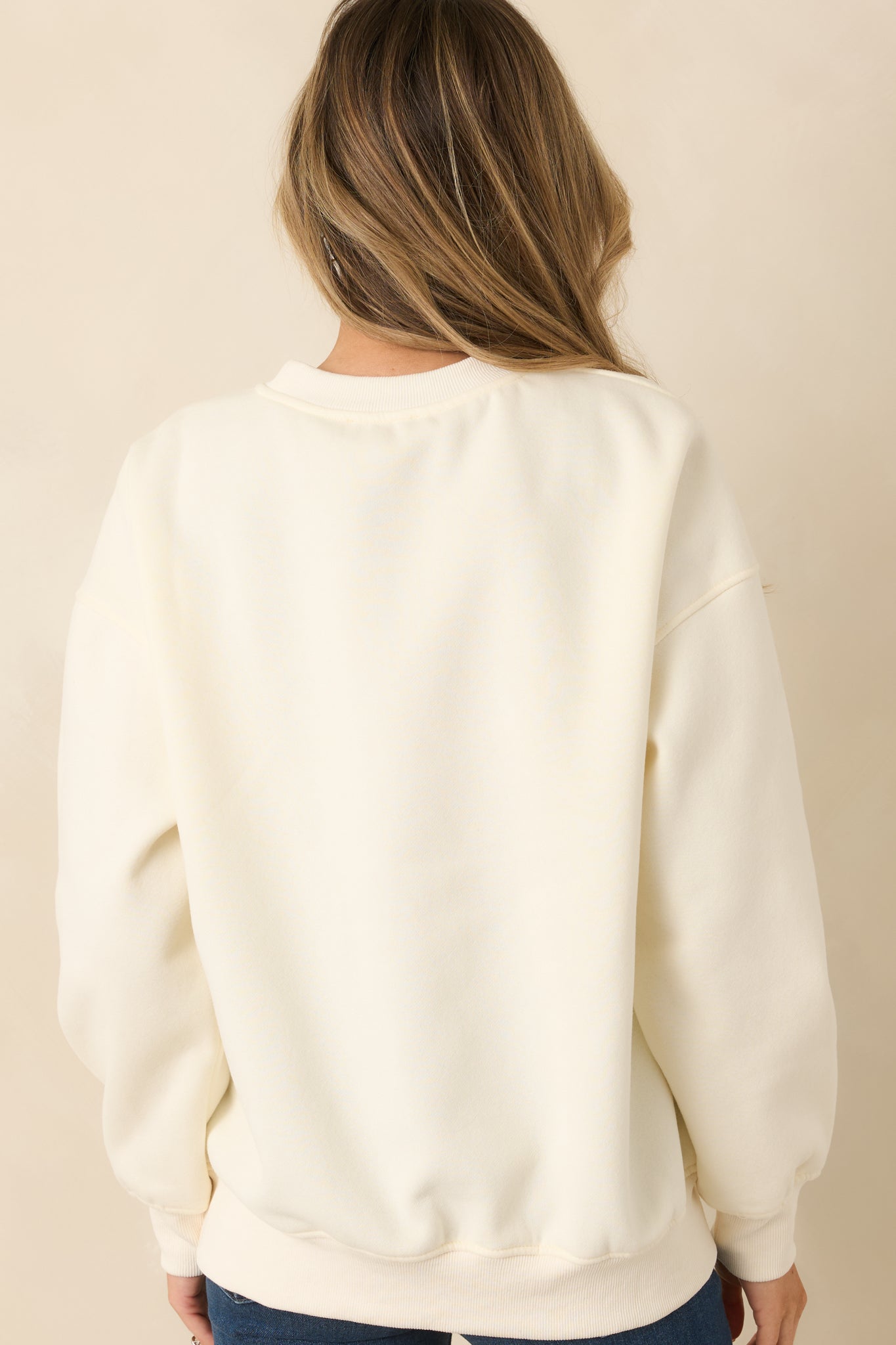 Back view of the ivory crewneck sweatshirt showing the relaxed fit and clean, smooth knit finish.