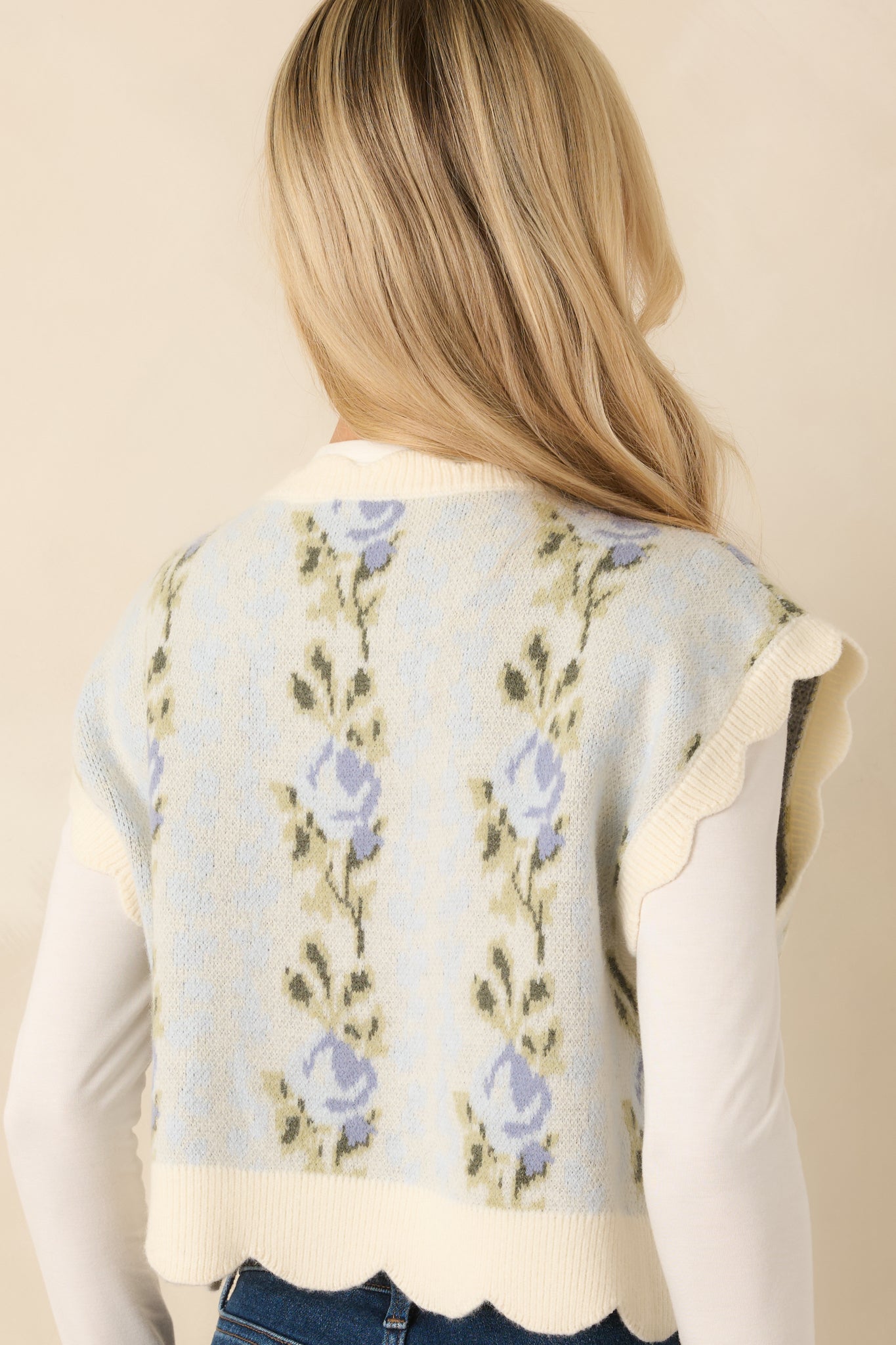 Cropped view emphasizing the cropped silhouette and delicate allover floral pattern of the light blue vest.