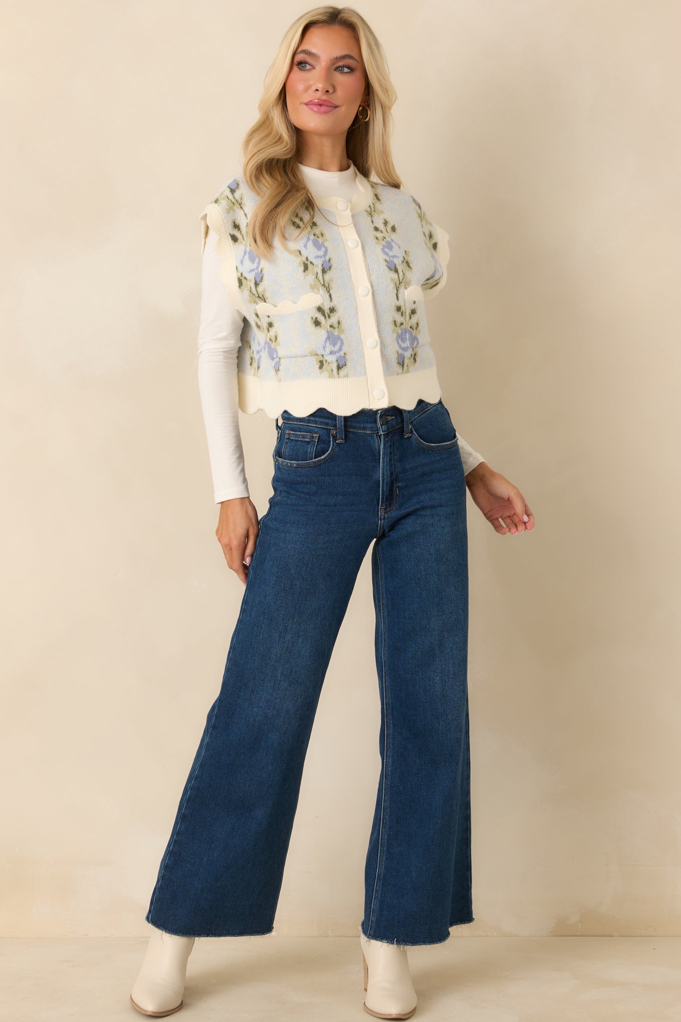 Front-facing view highlighting the scalloped trim along the neckline, arm openings, and hem of the light blue vest.