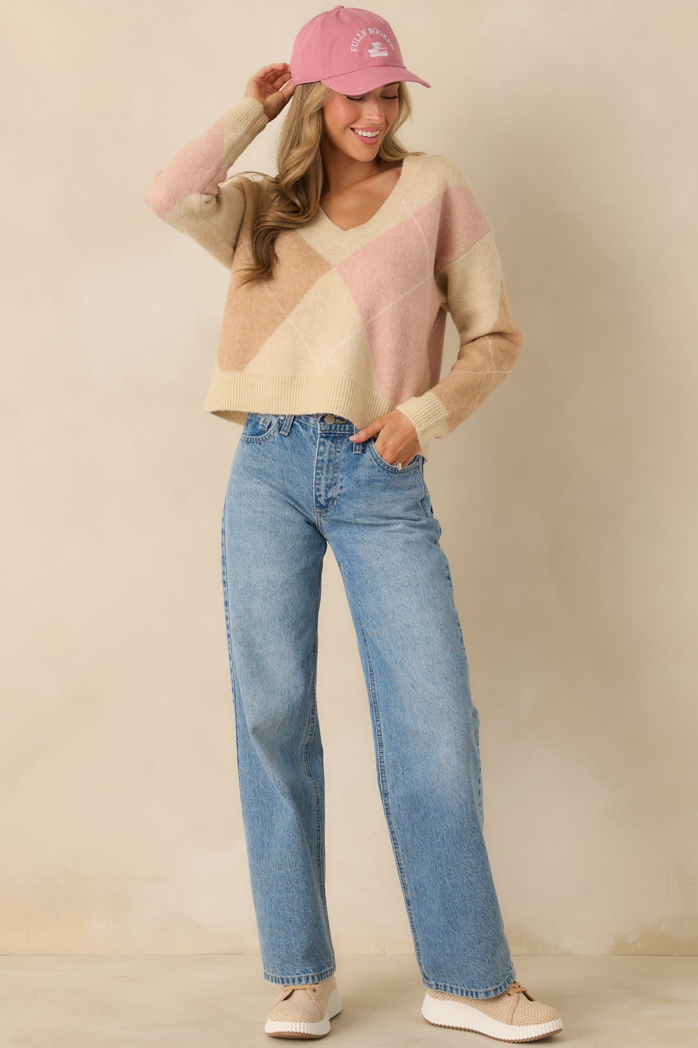 Taupe argyle sweater shown from the front highlighting the soft knit fabric and V-neck design.