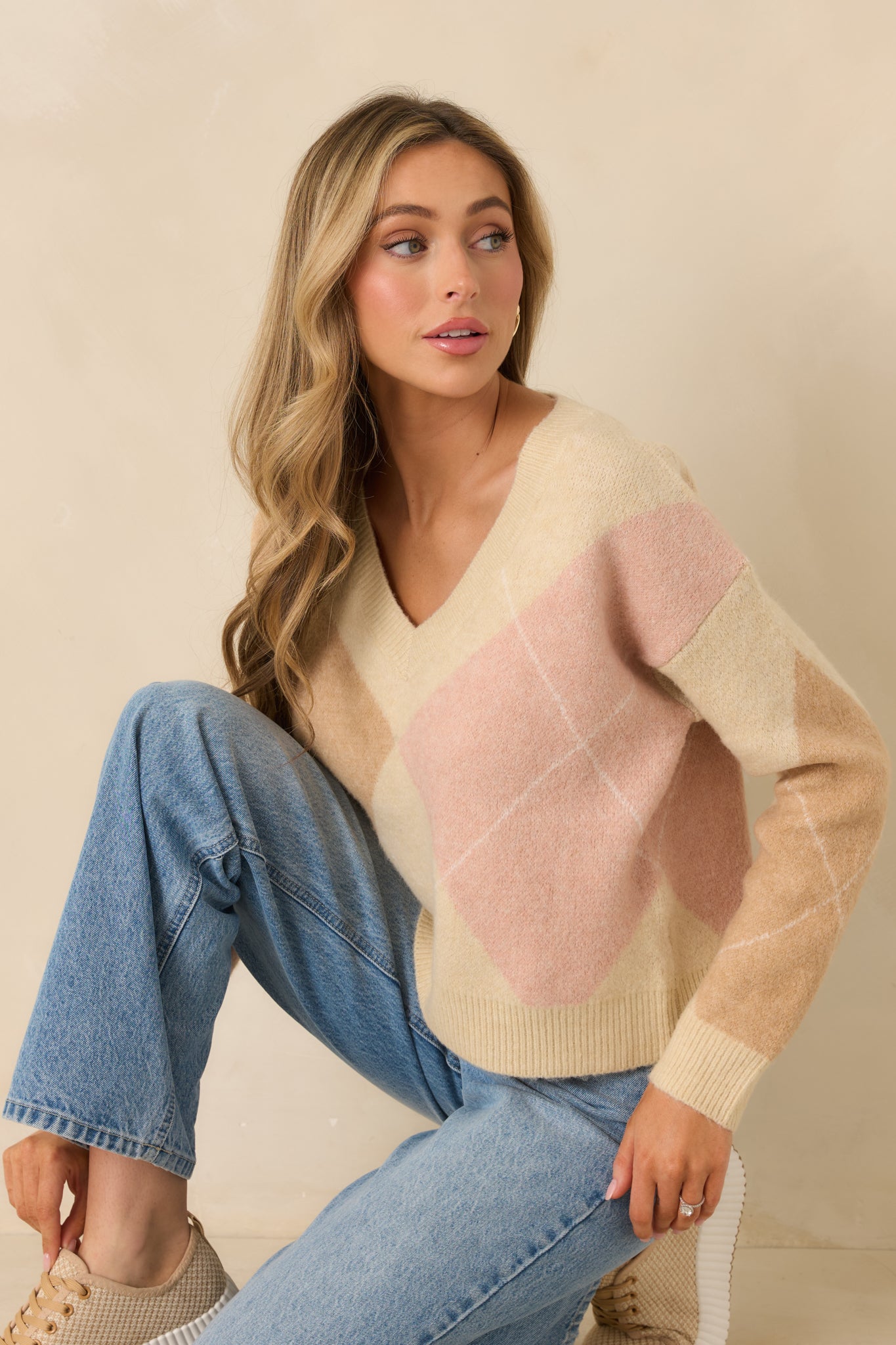 Cropped view showing V-neckline, ribbed hem, and textured knit pattern on taupe sweater.