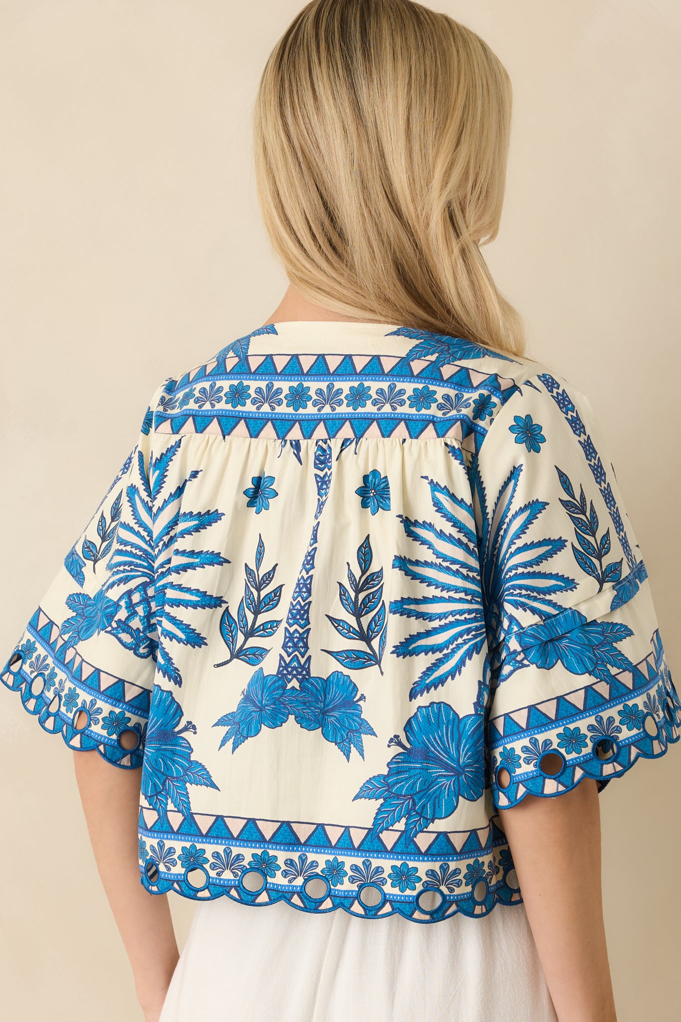 Rear view of the blue cotton top highlighting the relaxed short sleeves and straight hem.