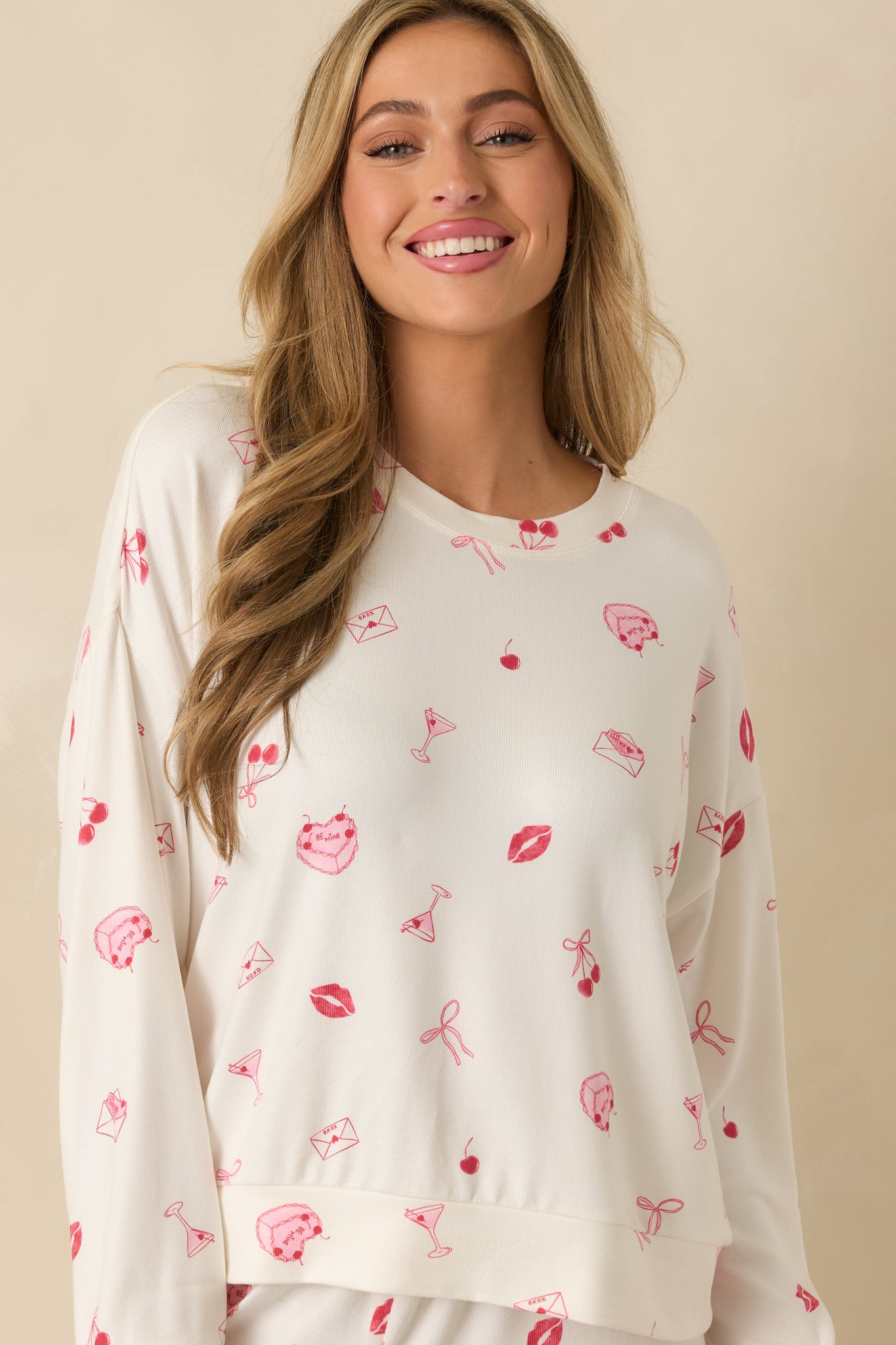 Ivory top showcasing long sleeves with ribbed cuff trim and smooth knit texture.