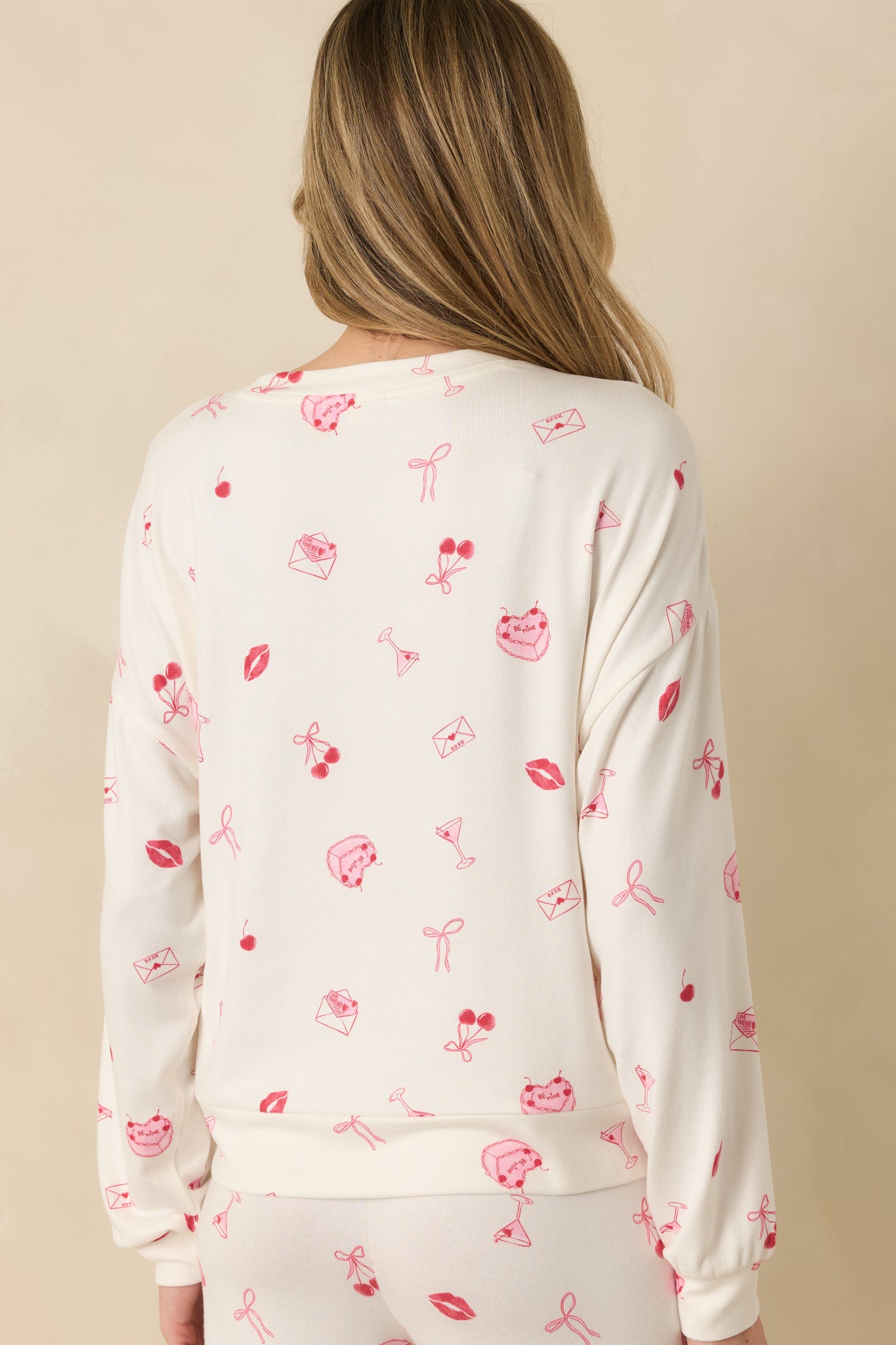Rear view of the ivory long sleeve top showing the relaxed silhouette and ribbed hem.