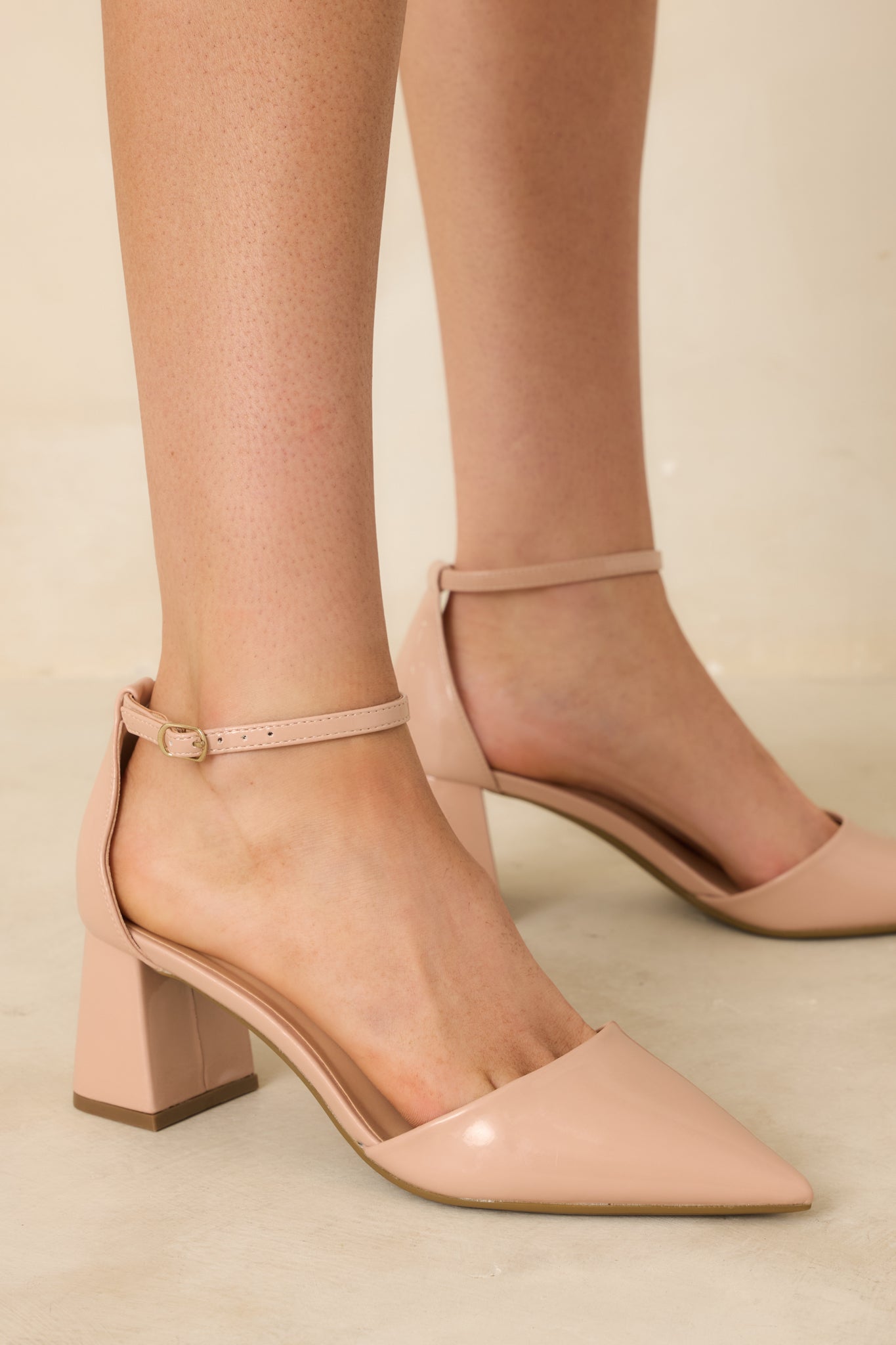 Beige patent heels highlighting the pointed toe and glossy finish