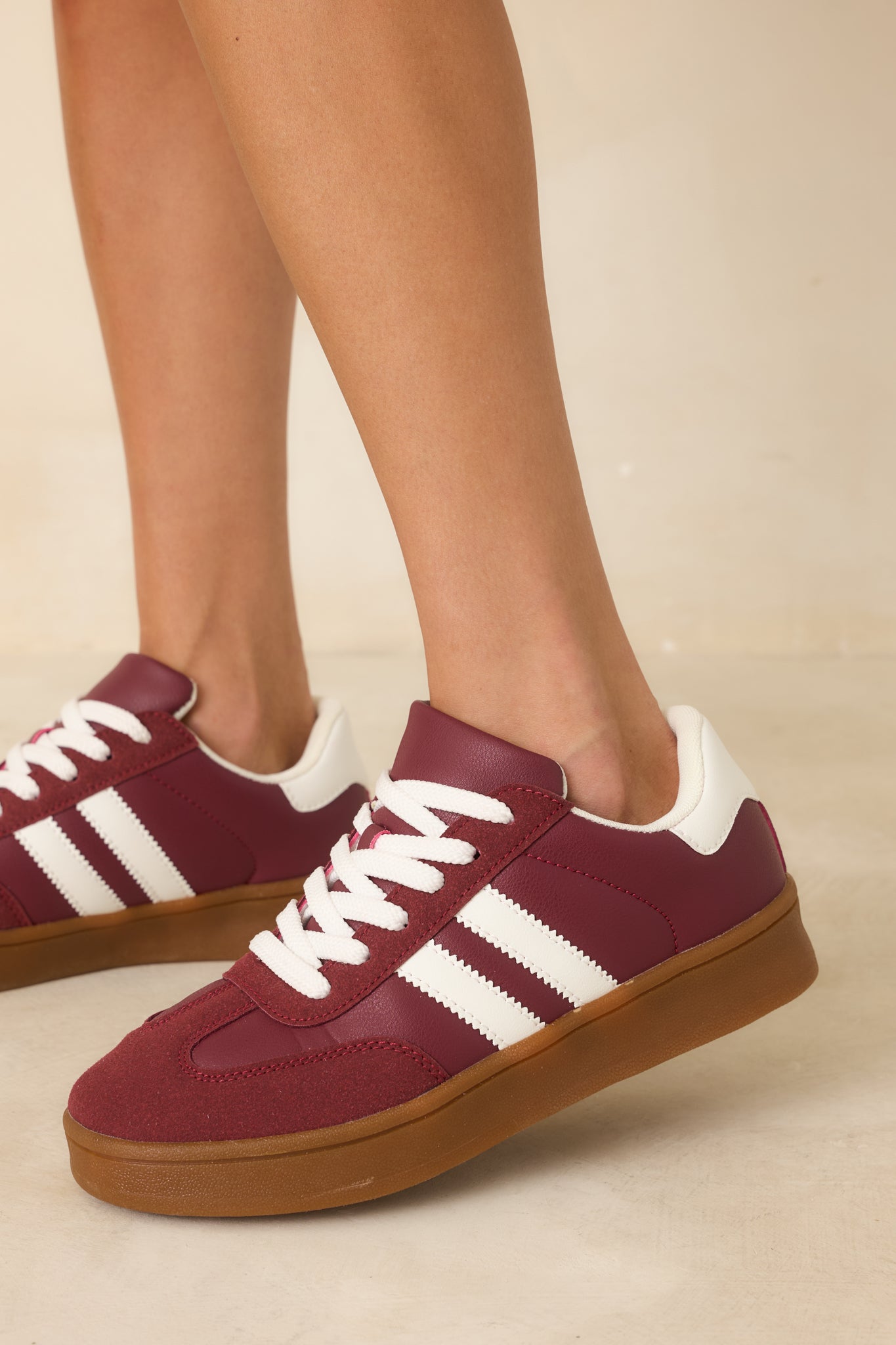Detailed view of the lace-up closure and padded collar in burgundy faux suede