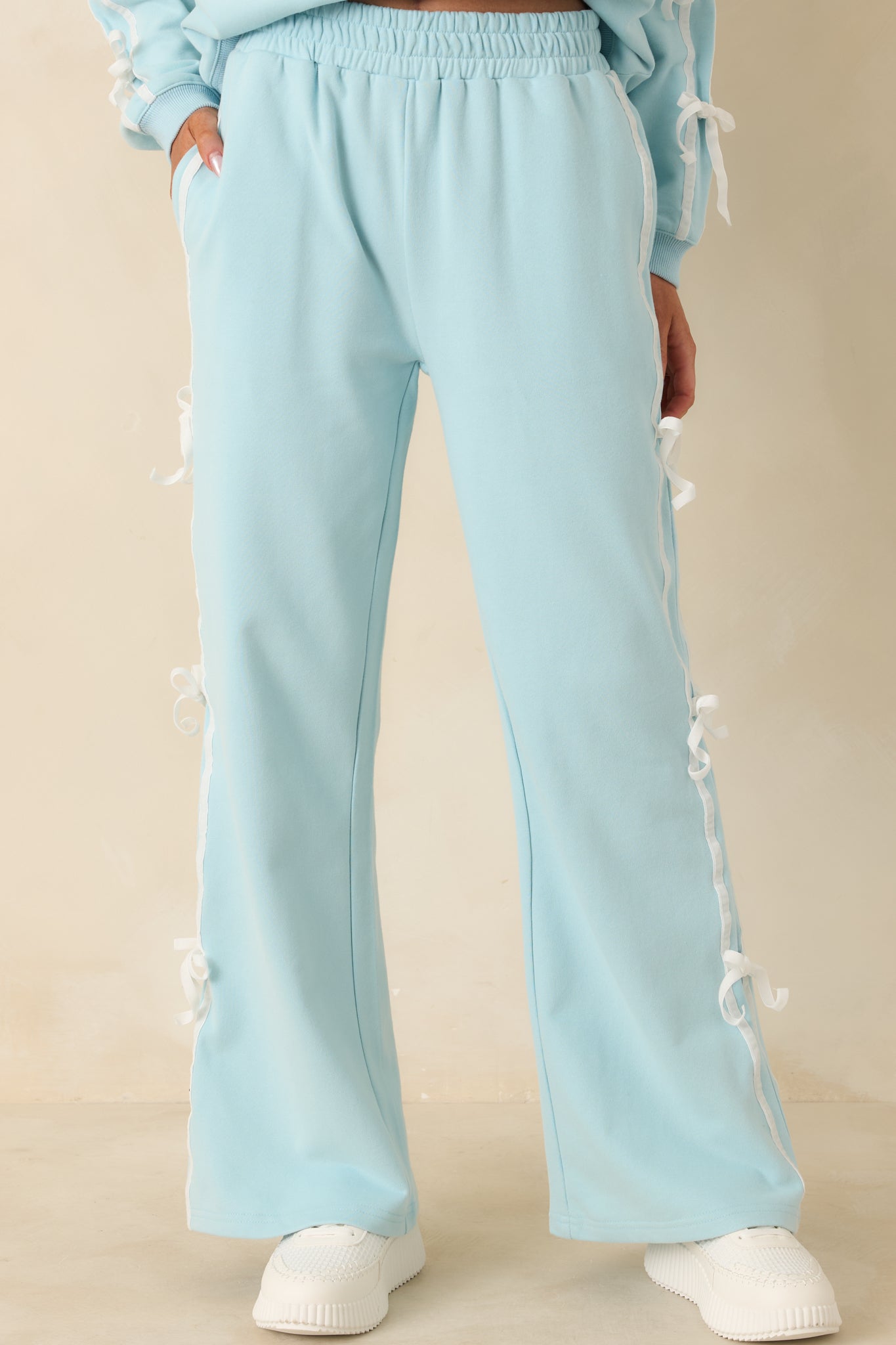 Focused detail of elastic waistband and knit texture on blue pants.